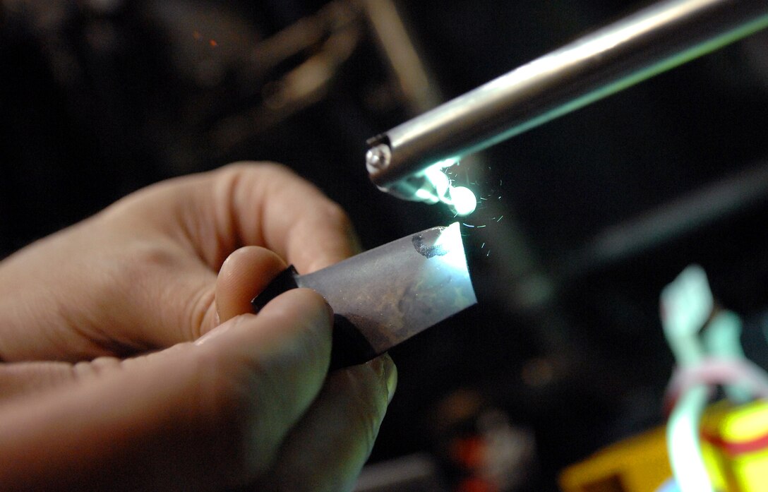 55th Aerospace Maintenance Squadron personnel demonstrate how the Wolf Blending Scope is used to grind down irregularities on damaged compressor blades inside an aircraft hangar at Offutt Air Force Base, Neb. March 19.. (U.S. Air Force photo by Delanie Stafford/Released)