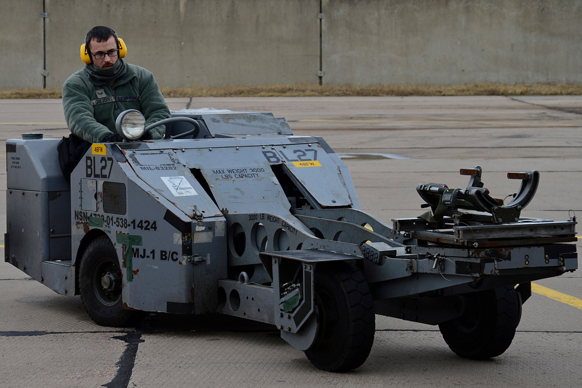 Senior Airman Jared Gregory, 48th Air Expeditionary Group weapons load crew member, drives an MJ-1 Lift Truck in preparation for weapons loading at Šiauliai Air Base, Lithuania, March 19, 2014. The 493rd Expeditionary Fighter Squadron regularly flies training missions while deployed to maintain readiness and proficiency. The U.S. Air Force F-15C Eagles' participation in the NATO Baltic Air Policing mission helps ensure a safe and stable future for the Baltics while preserving the integrity of NATO's borders and NATO security. (U.S. Air Force photo by Airman 1st Class Dana J. Butler/Released)