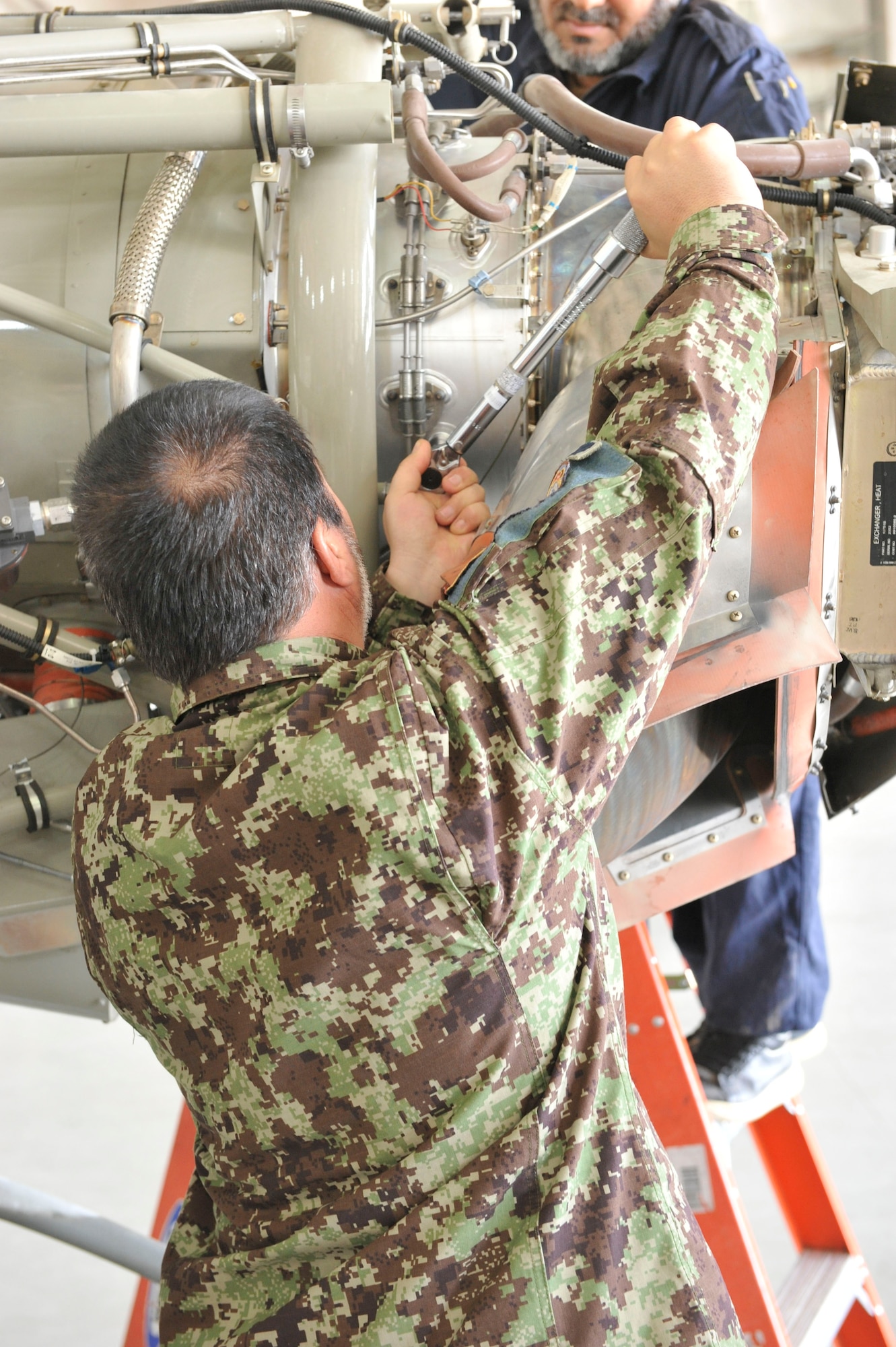 An Afghan aviation maintenance student uses a torque wrench on a Cessna 208 engine while being monitored by an Afghan crew chief during training at Shindand Airfield, Afghanistan, March 9, 2014. U.S. military advisors are training Afghan military members to fly and maintain aircraft at Shindand.(U.S. Air Force photo by Senior Master Sgt. Gary J. Rihn/Released)