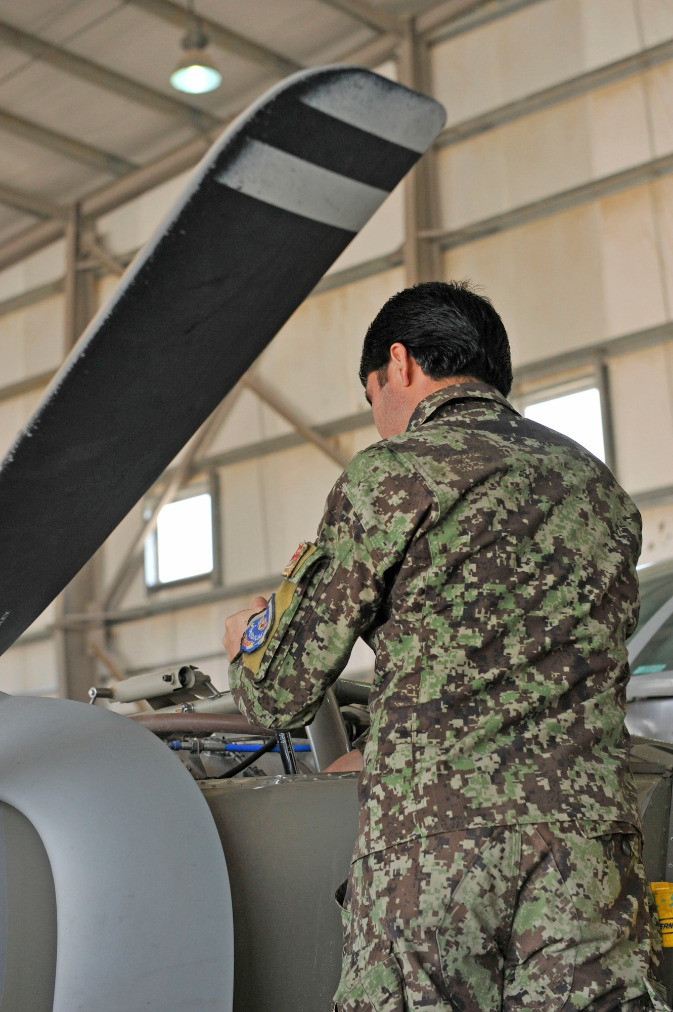 An Afghan aviation maintenance student works on a Cessna 208 engine during training at Shindand Airfield, Afghanistan, March 9, 2014. U.S. military advisors are training Afghan military members to fly and maintain aircraft at Shindand.(U.S. Air Force photo by Senior Master Sgt. Gary J. Rihn/Released)