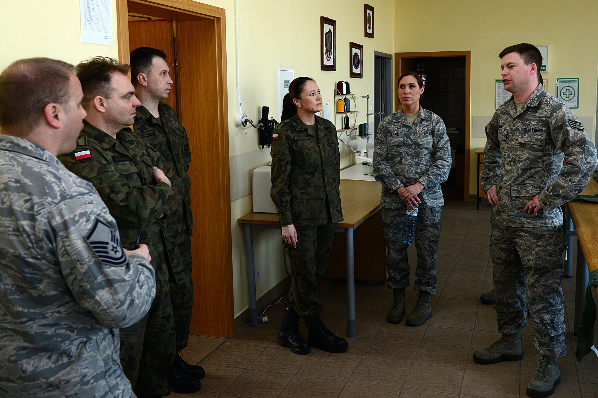 Aviano Airmen and Polish air force Airmen discuss operational procedures for aircrew flight equipment, March 20, 2014, at Lask Air Base, Poland. Airmen assigned to Aviano Air Base, Italy, toured AFE facilities in Poland to gain an understanding of the mission, field questions from NATO partners and promote interoperability throughout the ranks. (U.S. Air Force photo/Airman 1st Class Ryan Conroy)  