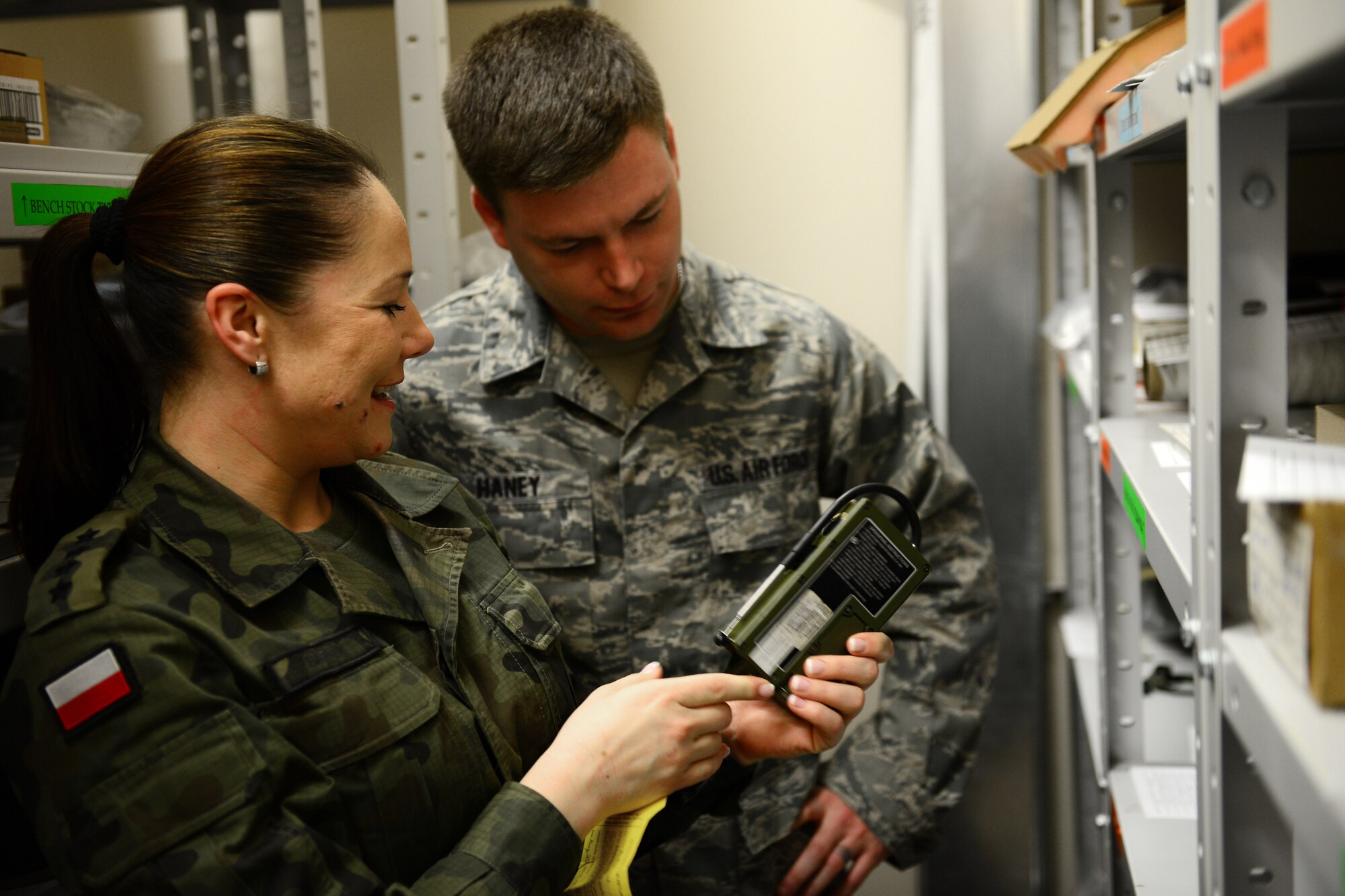 Polish air force Capt. Anna Sarnik asks U.S. Air Force Staff Sgt. James Haney questions about aircrew flight equipment that is commonly used by both countries, March 20, 2014, at Lask Air Base, Poland. Airmen assigned to Aviano Air Base, Italy, toured AFE facilities in Poland to gain an understanding of the mission, field questions from NATO partners and promote interoperability throughout the ranks. (U.S. Air Force photo/Airman 1st Class Ryan Conroy)  