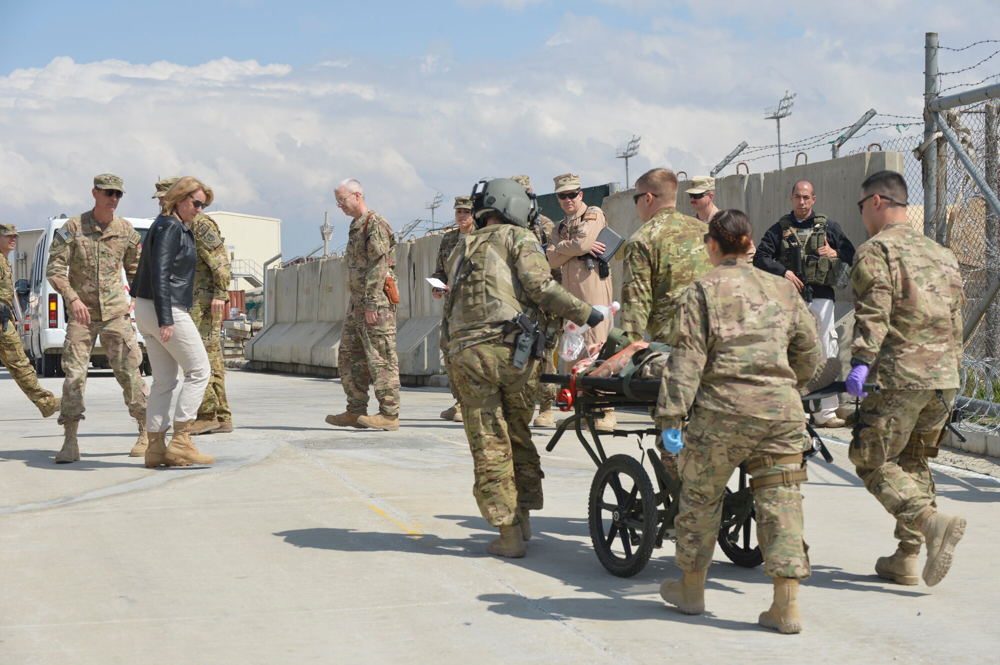 Secretary of the Air Force Deborah Lee James watches as the 455th Expeditionary Medical Group wheels a patient to the hospital after being unloaded from a Blackhawk medevac helicopter as part of an exercise at Bagram Airfield, Afghanistan, March 22, 2014. The EMDG simulated taking a patient through the entire process of medevac to the recovery room for James as part of her first visit to Afghanistan. (U.S. Air Force photo by Senior Master Sgt. Gary J. Rihn/Released)