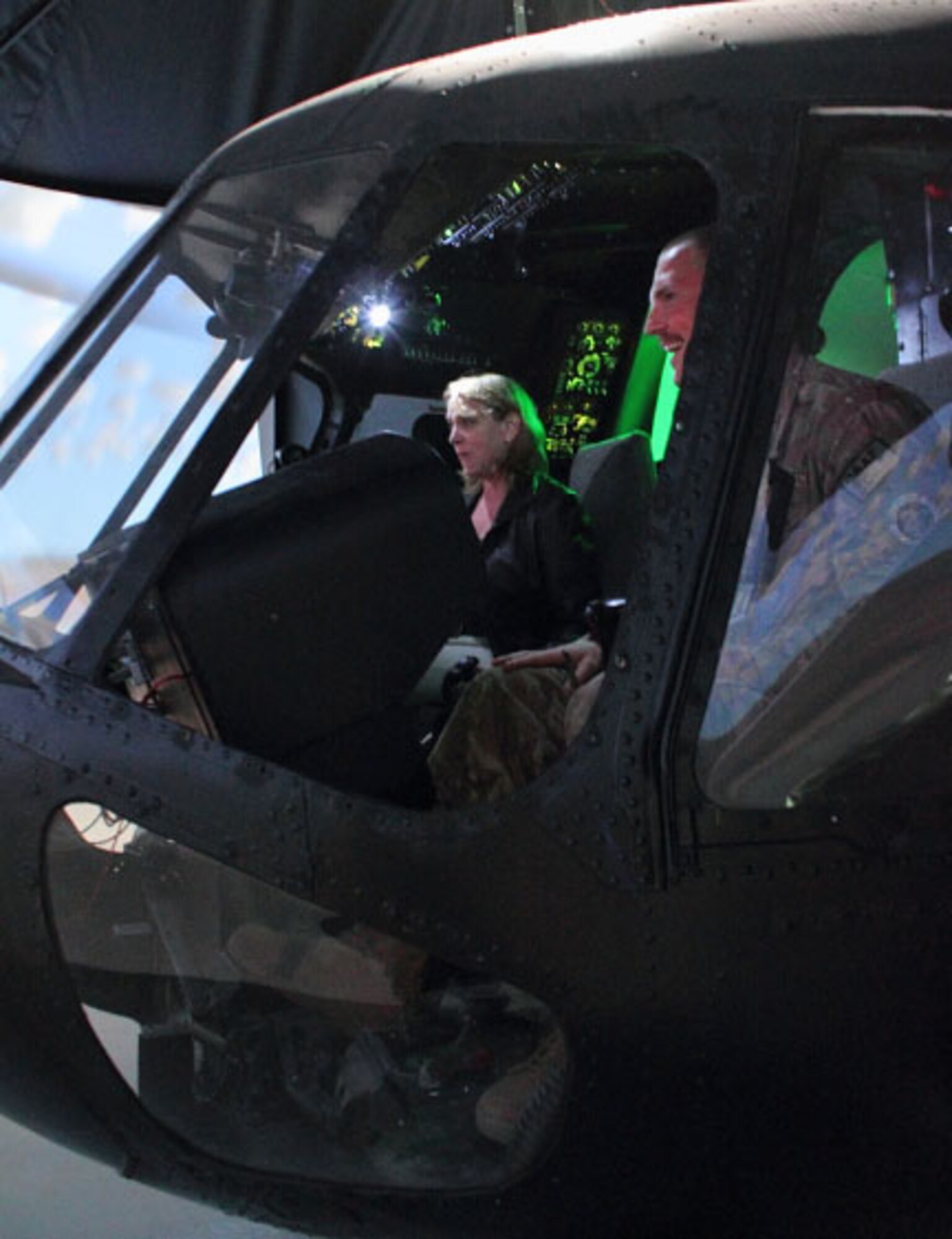 U.S. Air Force Maj. Henry Luke talks to Secretary of the Air Force Deborah Lee James about a Russian-built MI-17 helicopter simulator used to train prospective Afghan pilots and aircraft maintainers at Shindand Airfield, Afghanistan, March 19, 2014. Advisors teach Afghan pilots to fly and maintain both fixed and rotary wing aircraft.(U.S. Air Force photo by Senior Airman Joshua Drake/Released)