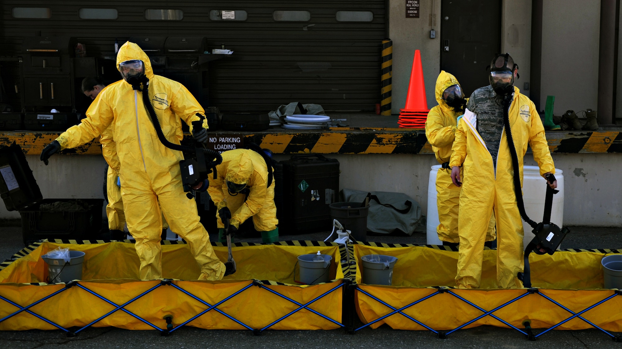 Emergency management technicians from the 51st Civil Engineer Squadron process through a decontamination line during chemical, biological, radiological and nuclear (CBRN) training at Osan Air Base, Republic of Korea, March 21, 2014. For two weeks, the EM Airmen trained with Marines from the 1st Marine Aircraft Wing out of Camp Foster, Japan, because of the organizations’ similar CBRN missions, which are used to provide combatant commanders the ability to respond and recover from any event involving hazardous materials. (U.S. Air Force photo/Senior Airman Siuta B. Ika)