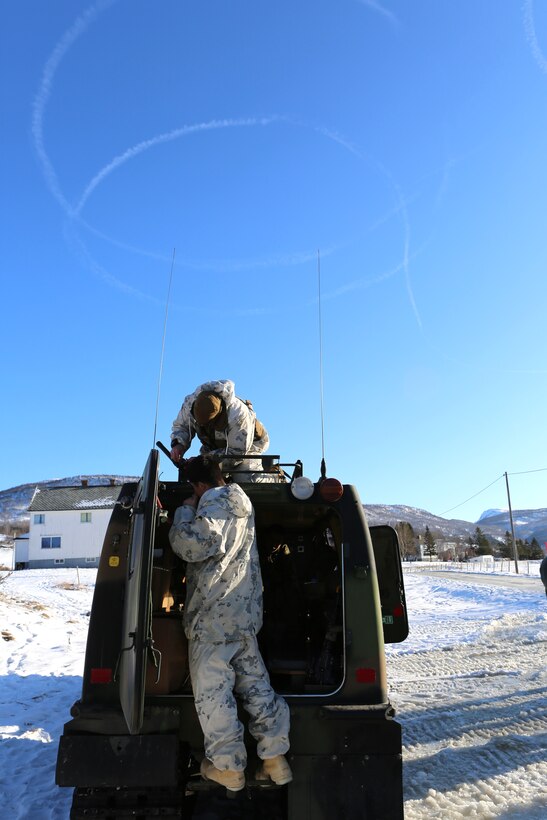Marines prepare the communications equipment on a Bandvagn 206, an all-terrain belted vehicle, during Cold Response 14. Cold Response 14 brought together nearly 16,000 troops from 16 countries to train high-intensity operations in the unique climate above the Arctic Circle and strengthen the alliance of partners and their commitment to global security in every clime and place.