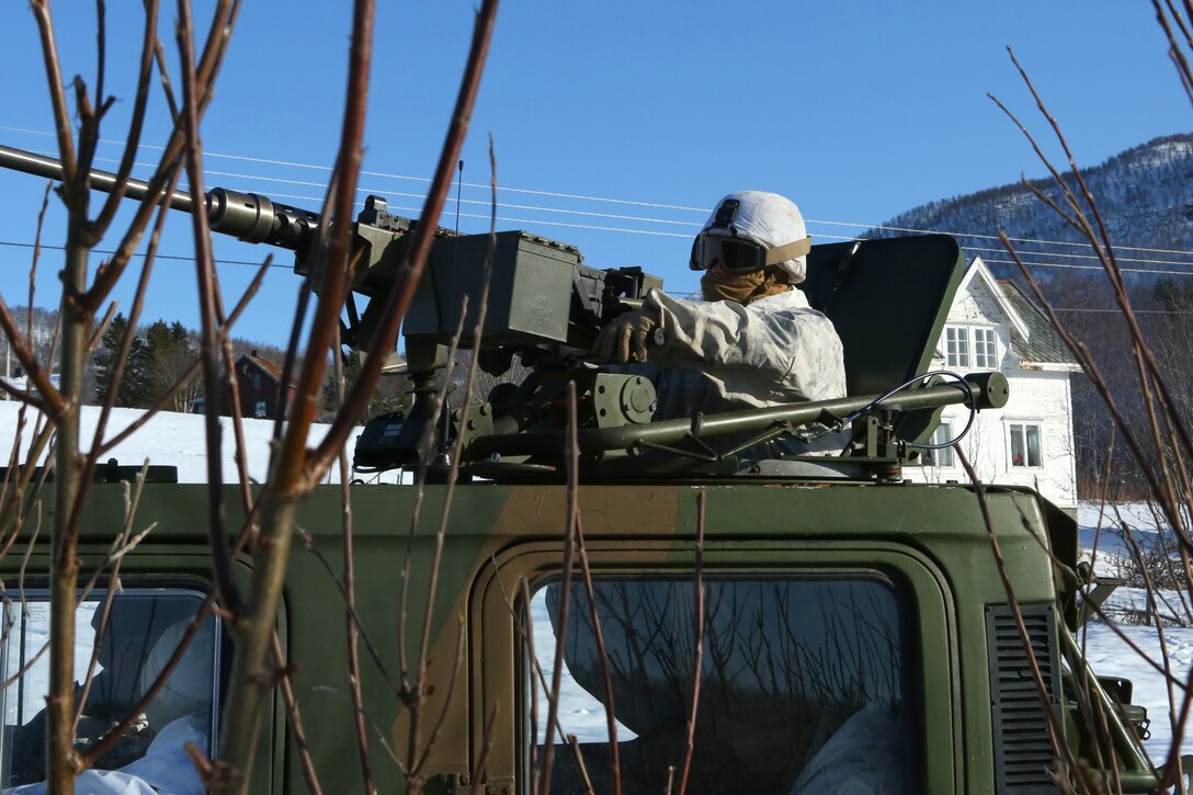 A Marine posts security from a Bandvagn 206, an all-terrain belted vehicle, during Cold Response 14. Cold Response 14 brought together nearly 16,000 troops from 16 countries to train high-intensity operations in the unique climate above the Arctic Circle and strengthen the alliance of partners and their commitment to global security in every clime and place.