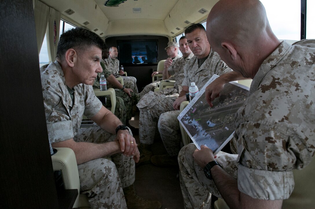 Col. James G. Flynn, right, discusses an aerial map of Marine Corps Air Station Futenma with Maj. Gen. Juan G. Ayala, left, March 25 during a windshield tour of the installation. Ayala and other distinguished guests toured Marine Corps installations on Okinawa during a two-day visit. Ayala is also scheduled to visit Combined Arms Training Center Camp Fuji and MCAS Iwakuni. Ayala is the commanding general of Marine Corps Installations Command. Flynn is the commanding officer of MCAS Futenma. 