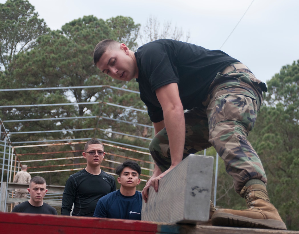 Raymond Lessig, a Notasulga Ala., native maneuvers a plank onto the platform of an obstacle during the Leader Ship Reaction Course here , March 22,2014. Lessig in one of more than 400 officer candidates from across the Southeastern United States that participated in a three-day mini Officer
Candidates School in preparation for Offier Candidates School in Quantico, Va. Lessig is currently attending Auburn University and plans to commission through the  Marine Corps' Platoon Leader's Course.  Through the PLC program, Lessig will attend training during his summer breaks from college
to earn his commission. (Photo by Lance Cpl. Stanley Cao)