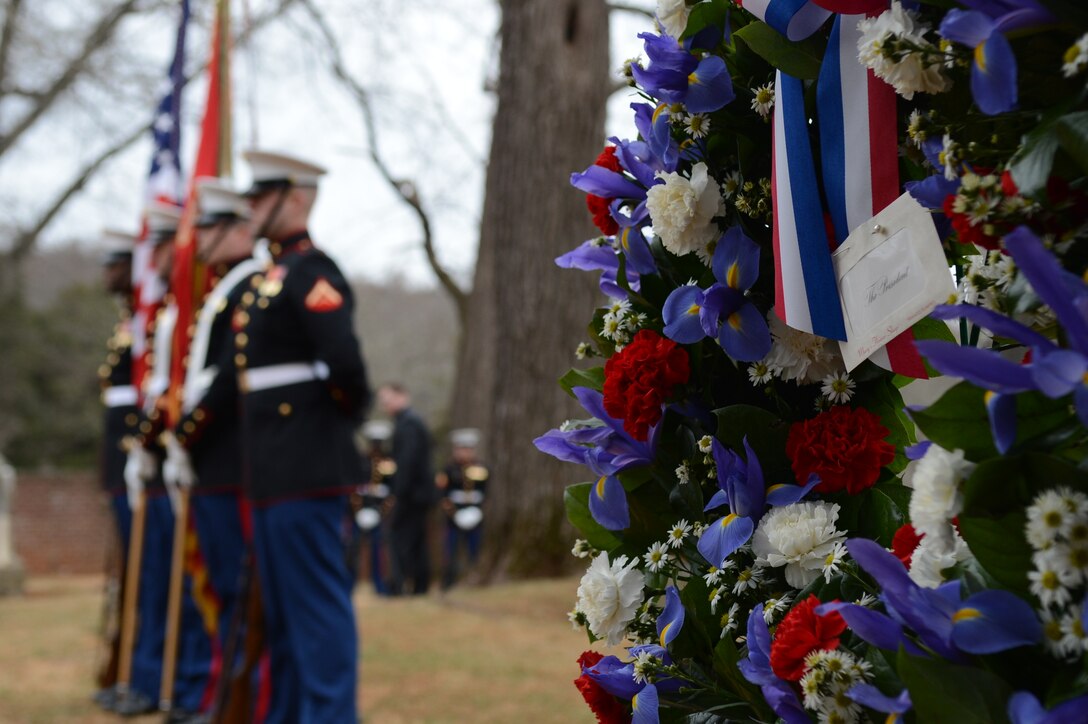 The Marine Corps Base Quantico Color Guard stands at ease beside a presidential wreath presented by Col. David Maxwell, Marine Corps Base Quantico base commander, on behalf of President Barack Obama on March 16, 2014. Each year, wreaths are laid at the final resting places of former United States Presidents across the nation.