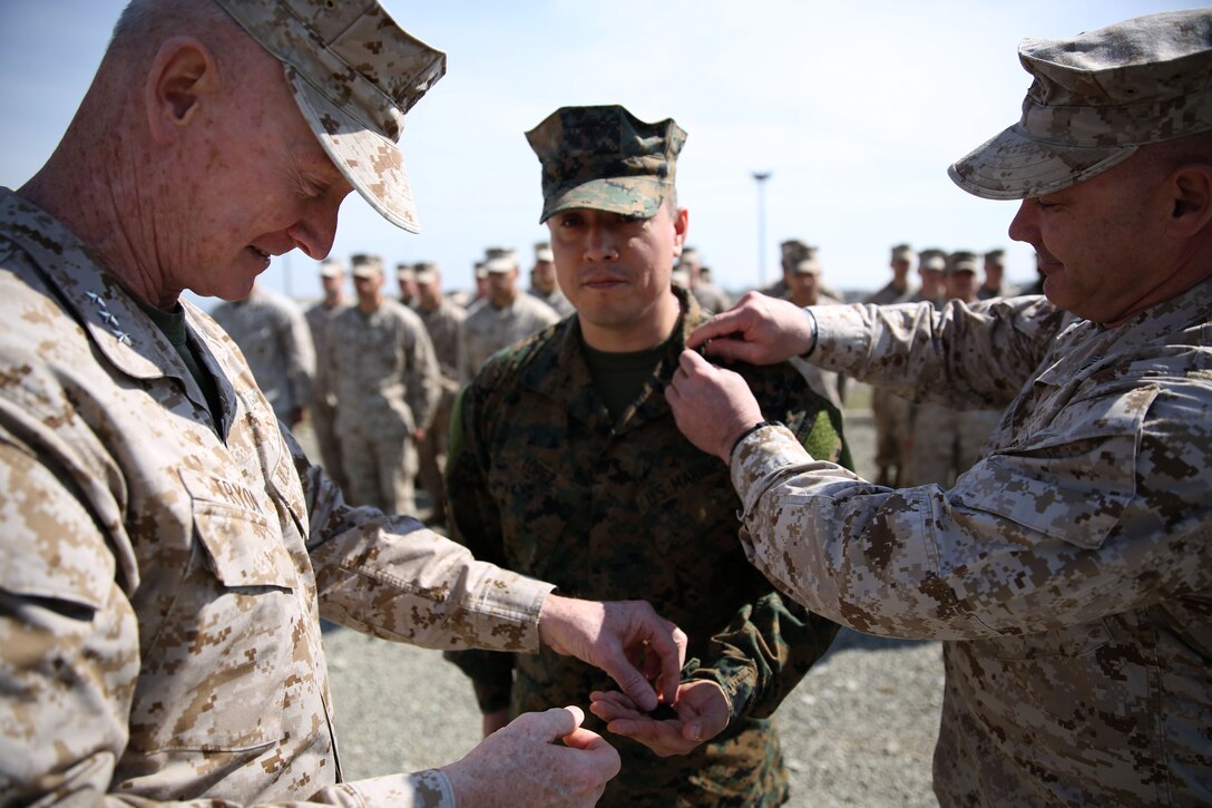 Lieutenant Gen. Richard Tryon, commander of U.S. Marine Corps Forces Command and U.S. Marine Corps Forces, Europe, and Master Gunnery Sgt. Troy Allen, the senior enlistment advisor of the Georgian Training Team pin the rank of master sergeant onto Master Sgt. Mario Lopez-Diaz, the senior enlisted advisor of Georgian Liaison Team 12, during his frocking ceremony March 20, 2014 aboard the Krstanisi National Training Center in Georgia. Georgian Liaison Team 12 is slated to deploy to Afghanistan as part of the International Security Assistance Force. Lopez-Diaz was frocked, which means he will wear the rank of master sergeant to fulfill his job position’s requirements, but will not receive any pay increase until he officially is promoted. (Official Marine Corps photo by Lance Cpl. Scott W. Whiting, BSRF PAO/ Released)