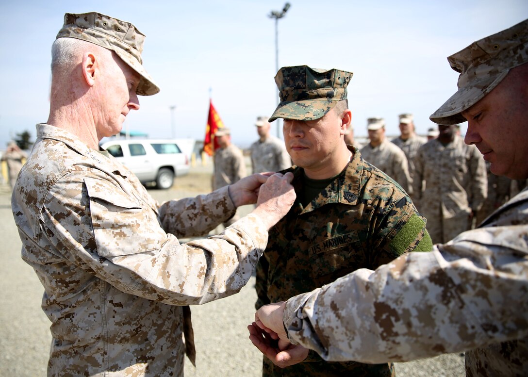 Lieutenant Gen. Richard Tryon, commander of U.S. Marine Corps Forces Command and U.S. Marine Corps Forces, Europe, and Master Gunnery Sgt. Troy Allen, the senior enlistment advisor of the Georgian Training Team pin the rank of master sergeant onto Master Sgt. Mario Lopez-Diaz, the senior enlisted advisor of Georgian Liaison Team 12, during his frocking ceremony March 20, 2014 aboard the Krstanisi National Training Center in Georgia. Georgian Liaison Team 12 is slated to deploy to Afghanistan as part of the International Security Assistance Force. Lopez-Diaz was frocked, which means he will wear the rank of master sergeant to fulfill his job position’s requirements, but will not receive any pay increase until he officially is promoted. (Official Marine Corps photo by Lance Cpl. Scott W. Whiting, BSRF PAO/ Released)