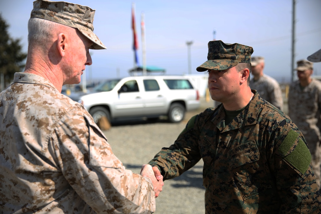 Lieutenant Gen. Richard Tryon, commander of U.S. Marine Corps Forces Command and U.S. Marine Corps Forces, Europe, and Master Sgt. Mario Lopez-Diaz, the senior enlisted advisor of Georgian Liaison Team 12, shake hands after Lopez-Diaz’s frocking ceremony March 20, 2014 aboard the Krstanisi National Training Center in Georgia. Georgian Liaison Team 12 is slated to deploy to Afghanistan as part of the International Security Assistance Force. Lopez-Diaz was frocked, which means he will wear the rank of master sergeant to fulfill his job position’s requirements, but will not receive any pay increase until he officially is promoted. (Official Marine Corps photo by Lance Cpl. Scott W. Whiting, BSRF PAO/ Released)