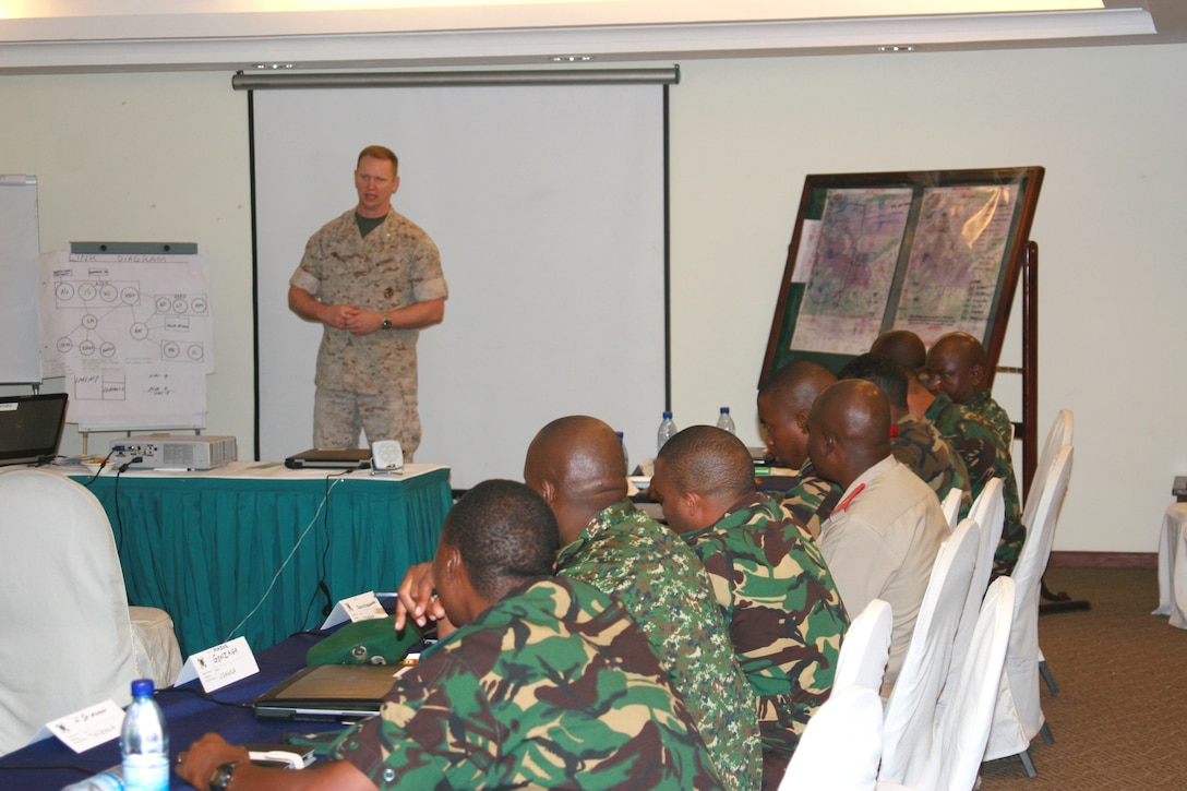 U.S. Marine Corps Forces Europe and Africa Intelligence Chief-of-Staff Lt. Col. Vernon Williams addresses the 25 Military Intelligence Basic Officer’s Course-Africa students from the nations of Tanzania, Uganda, Burundi, Djibouti, and Kenya during the course’s Final Exercise.  The current MIBOC-A is the tenth iteration of the program and is U.S. Africa Command’s flagship intelligence building course to enhance multinational interoperability between partners on the African continent.