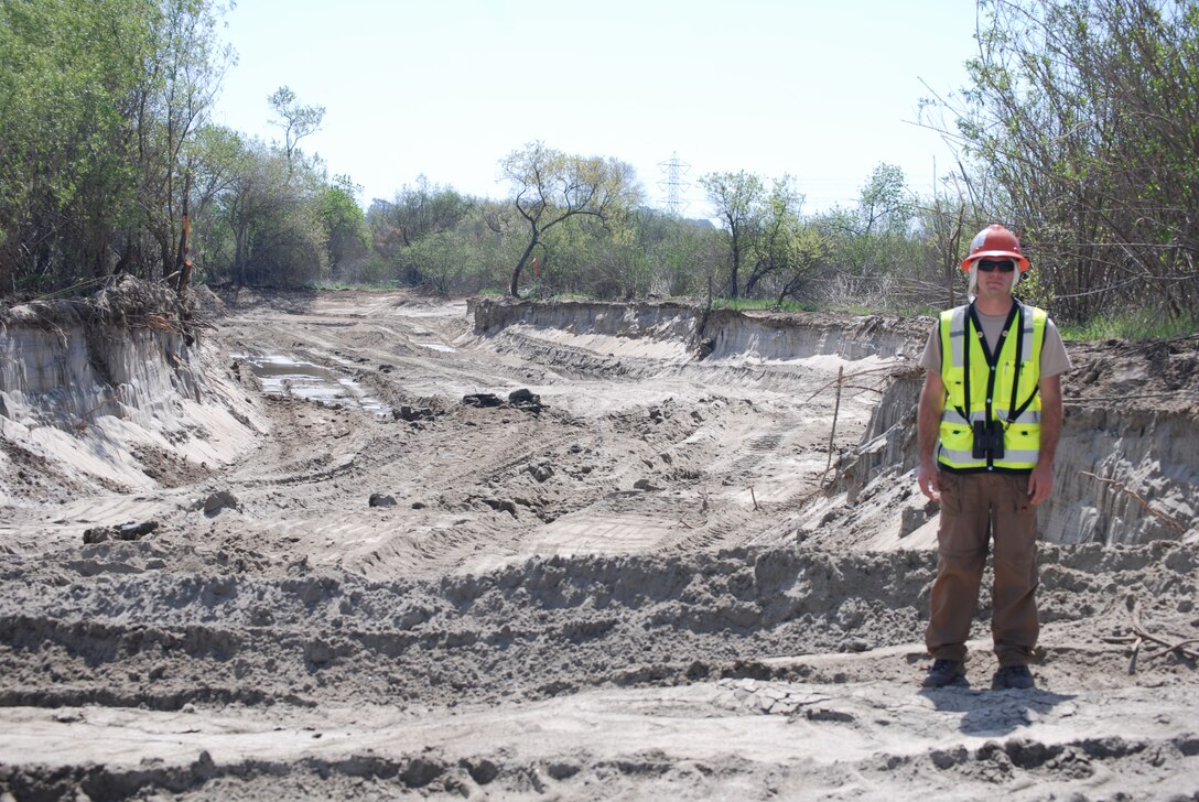 Alex Fromer, a biologist with RECON Environmental, provides perspective as he stands near a segment of the diversion channel that will help recreate the wetlands environment that is being constructed as part of the mitigation for the San Luis Rey River flood risk reduction project.
