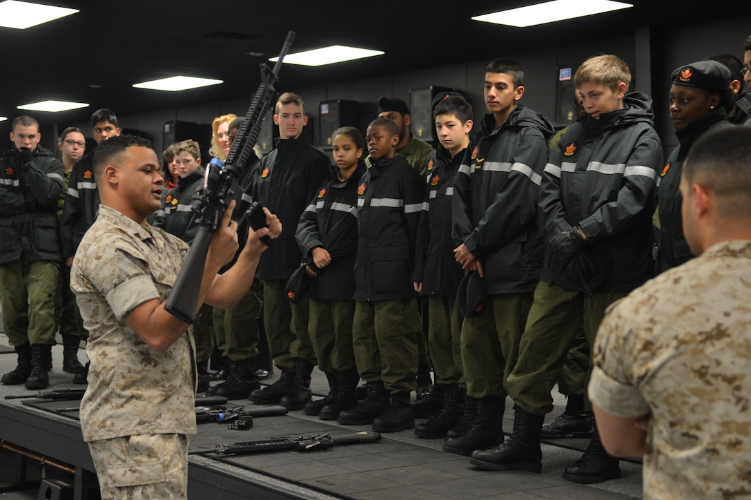 Cpl. Caleb O’Herien, indoor simulated marksmanship trainer instructor, Reserve Support Unit, explains to the 557 Lorne Scots Royal Canadian Army Cadets how to work their weapon before the start of the indoor simulated marksmanship trainer at Camp Upshur aboard Marine Corps Base Quantico on March 13, 2014. More than 40 cadets participated in the simulation.