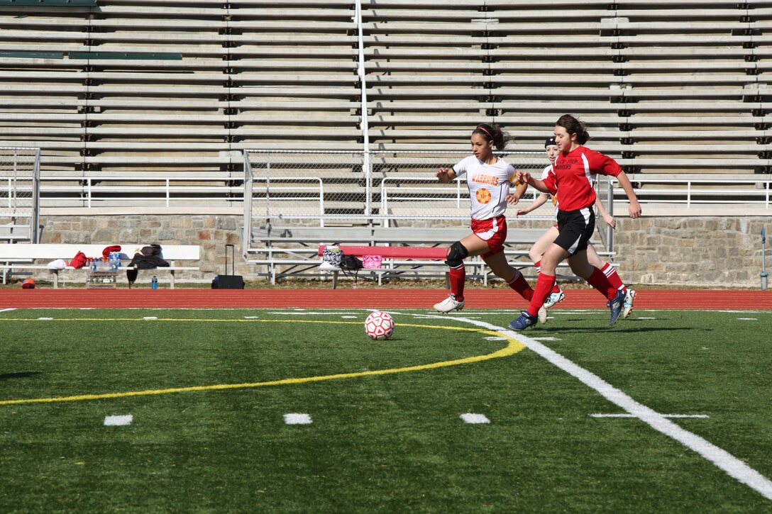 Missy, a junior for Quantico Middle/High School, runs down a ball against a player from Grace Preparatory School from Stafford, during a game at Butler Stadium on March 20, 2014. Quantico went on to win the game, 8-0.