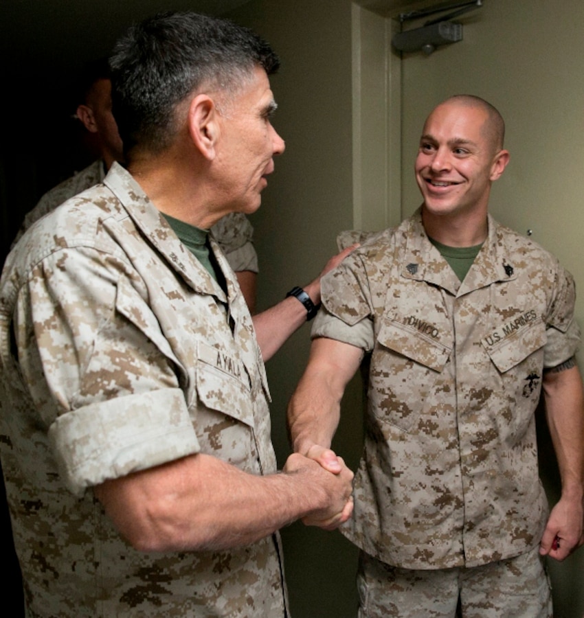 Maj. Gen. Juan G. Ayala, left, shakes hands with Sgt. Andrew M. Divico March 25, thanking him for a tour of the Headquarters and Headquarters Squadron barracks on Marine Corps Air Station Futenma. Ayala and other distinguished guests toured Marine Corps installations on Okinawa during a two-day visit. Ayala is scheduled to visit Combined Arms Training Center Camp Fuji and MCAS Iwakuni. Divico is an aircraft rescue and firefighting specialist with H&HS, MCAS Futenma, Marine Corps Installations Pacific Ayala is the commanding general of Marine Corps Installations Command. 