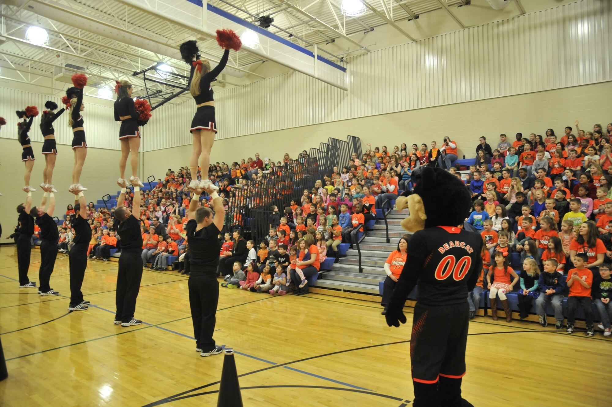 University of Cincinnati cheerleaders perform with their mascot, Bearcat, and pep band at Michael Anderson Elementary School on Fairchild Air Force Base, Wash., March 19, 2014. During their visit, the group toured a KC-135 Stratotanker and performed across the base in hopes to boost morale and visit with Airmen. (U.S. Air Force photo by Senior Airman Mary O'Dell/Released)