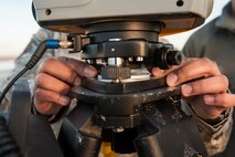 A Trimble Total Station is adjusted at Minot Air Force Base, N.D., March 19, 2014. The station is used to ensure that a Precision Approach Path Indicator is properly aligned so that it can act as temporary runway lighting during construction on the flight line later this year. This summer, Minot AFB in coordination with Sundt Construction and the United States Army Corps of Engineers will be performing a $32.8 million runway repair project to replace close to 9,000 feet of the center keel section.  (U.S. Air Force photo/Senior Airman Stephanie Sauberan)