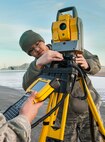 Airman 1st Class Trojan Dimagan, 5th Civil Engineer Squadron engineering apprentice adjusts a Trimble Total Station at Minot Air Force Base, N.D., March 19, 2014. The station will be used to check the alignment of a Precision Approach Path Indicator which will act as temporary runway lighting during construction on the flight line later this year. (U.S. Air Force photo/Senior Airman Stephanie Sauberan)