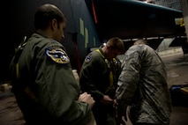 Staff Sgt. John M. Silva, 5th Aircraft Maintenance Squadron dedicated crew chief, puts harnesses on 69th Bomb Squadron pilots Capt. Joseph Cangealose and Capt. Britt Nemeth after an aircraft wash at Minot Air Force Base, N.D., Jan. 10, 2014. Silva promotes a strong working relationship between the two crews by including the air crew in maintenance shop functions. (U.S. Air Force photo/Senior Airman Brittany Y. Auld)