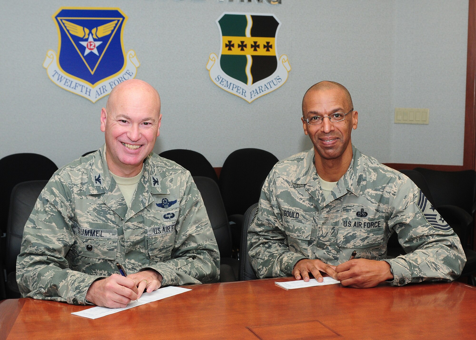Col. Quinn Gummel (left), 9th Reconnaissance Wing vice commander, and Chief Master Sgt. Leslie Gould, 9th RW command chief, make their contributions to the Air Force Assistance Fund March 25, 2014, at Beale Air Force Base, Calif. The campaign is an Air Force-wide program that benefits active-duty members, reserve, guard, retirees, and surviving spouses and families. (U.S. Air Force photo by Senior Airman Allen Pollard/Released)