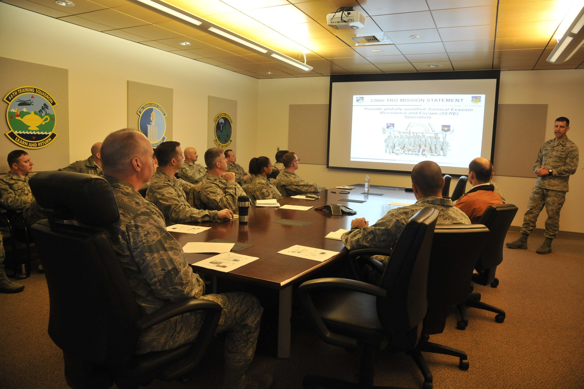Col. Konrad Klausner, 92nd Mission Support Group commander, along with MSG squadron commanders, first sergeants and superintendents, listen as Lt. Col. Andrew Reinsenweber, 336th Training Group deputy commander, gives a mission briefing before a tour of their facilities at Fairchild Air Force Base, Wash., March 20, 2014. MSG leadership immersed with the group to better understand the relationship between tenant units. (U.S. Air Force photo by Senior Airman Mary O'Dell/Released)