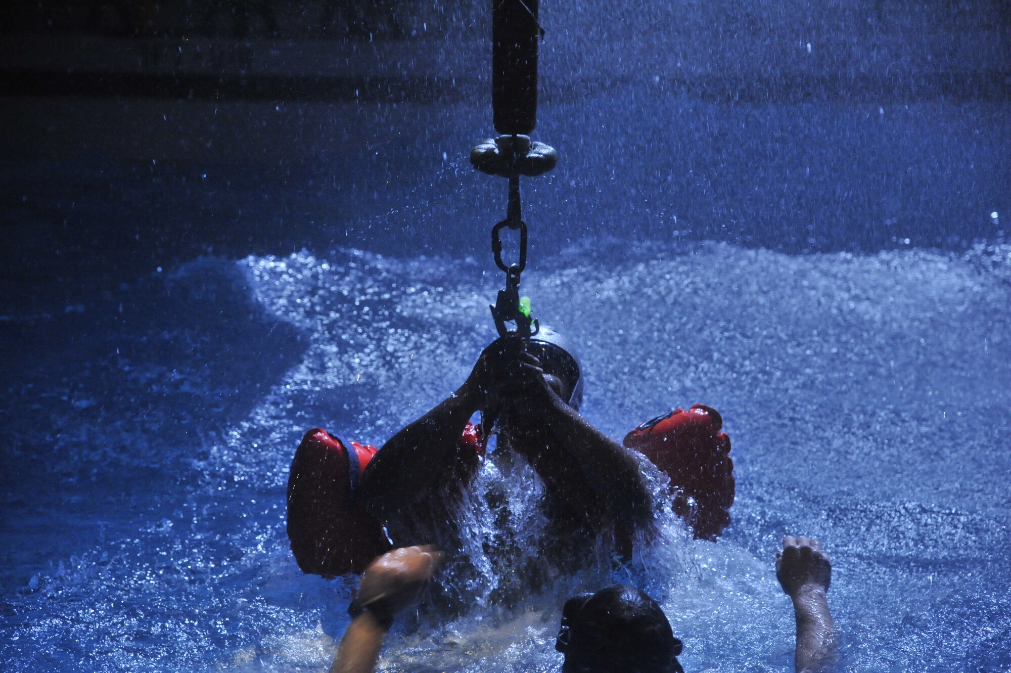 An Airman prepares to be hoisted during water survival training at Fairchild Air Force Base, Wash., March 21, 2014. There are two parts to the water survival course, SV84 and SV90, which include egressing from an aircraft underwater and surviving in open water areas until they can be recovered. (U.S. Air Force photo by Senior Airman Mary O'Dell/Released)