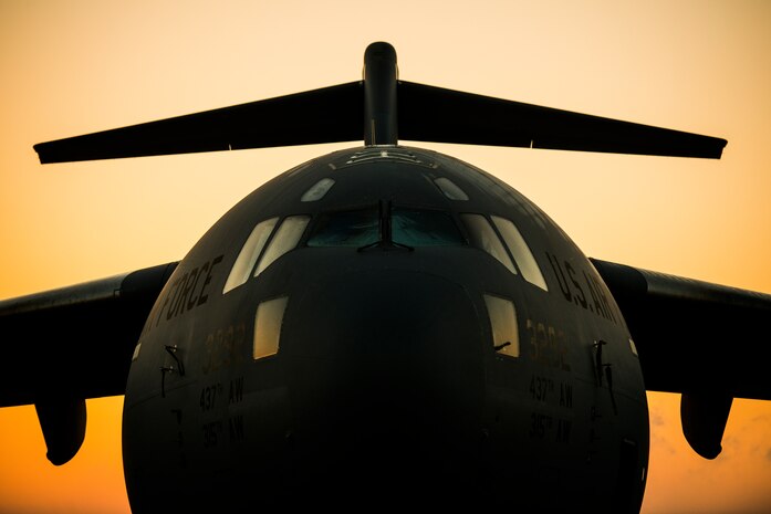 The sun rises above a C-17 Globemaster III assigned to the 437th Airlift Wing March 24, 2014, at Joint Base Charleston, S.C. The first C-17 to enter the Air Force’s inventory arrived at Charleston Air Force Base in June 1993. The C-17 is capable of rapid strategic delivery of troops and all types of cargo to main operating bases or directly to forward bases in the deployment area. (U.S. Air Force photo/Senior Airman Dennis Sloan)