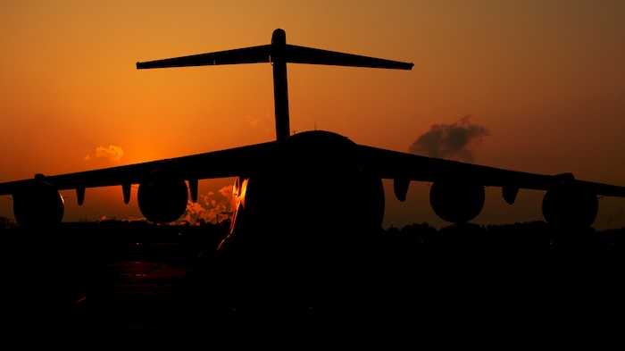 The sun rises above a C-17 Globemaster III assigned to the 437th Airlift Wing March 24, 2014, at Joint Base Charleston, S.C. The first C-17 to enter the Air Force’s inventory arrived at Charleston Air Force Base in June 1993. The C-17 is capable of rapid strategic delivery of troops and all types of cargo to main operating bases or directly to forward bases in the deployment area. (U.S. Air Force photo/Senior Airman Dennis Sloan)