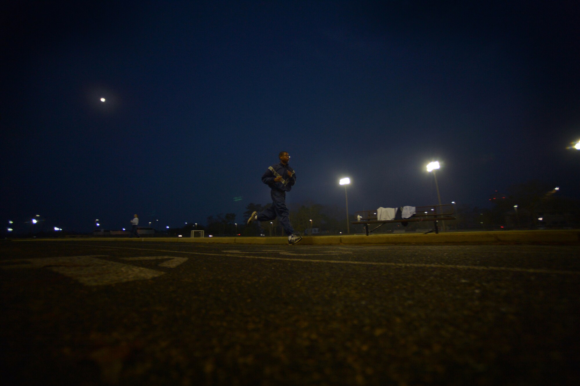 A U.S. Air Force Staff Sgt. assigned to the 20th Comptroller Squadron, runs laps during an early morning physical training session, March 20, 2014, Shaw Air Force Base, S.C. daylight saving time has played a factor for some units that conduct early morning physical training sessions. These units now have to take in account low light conditions. To counter the less than optimal physical training conditions military members are encouraged to wear proper reflective gear and take the necessary measures to stay safe when training during the hours of darkness. (U.S. Air Force photo by Staff Sgt. Kenny Holston/Released)   