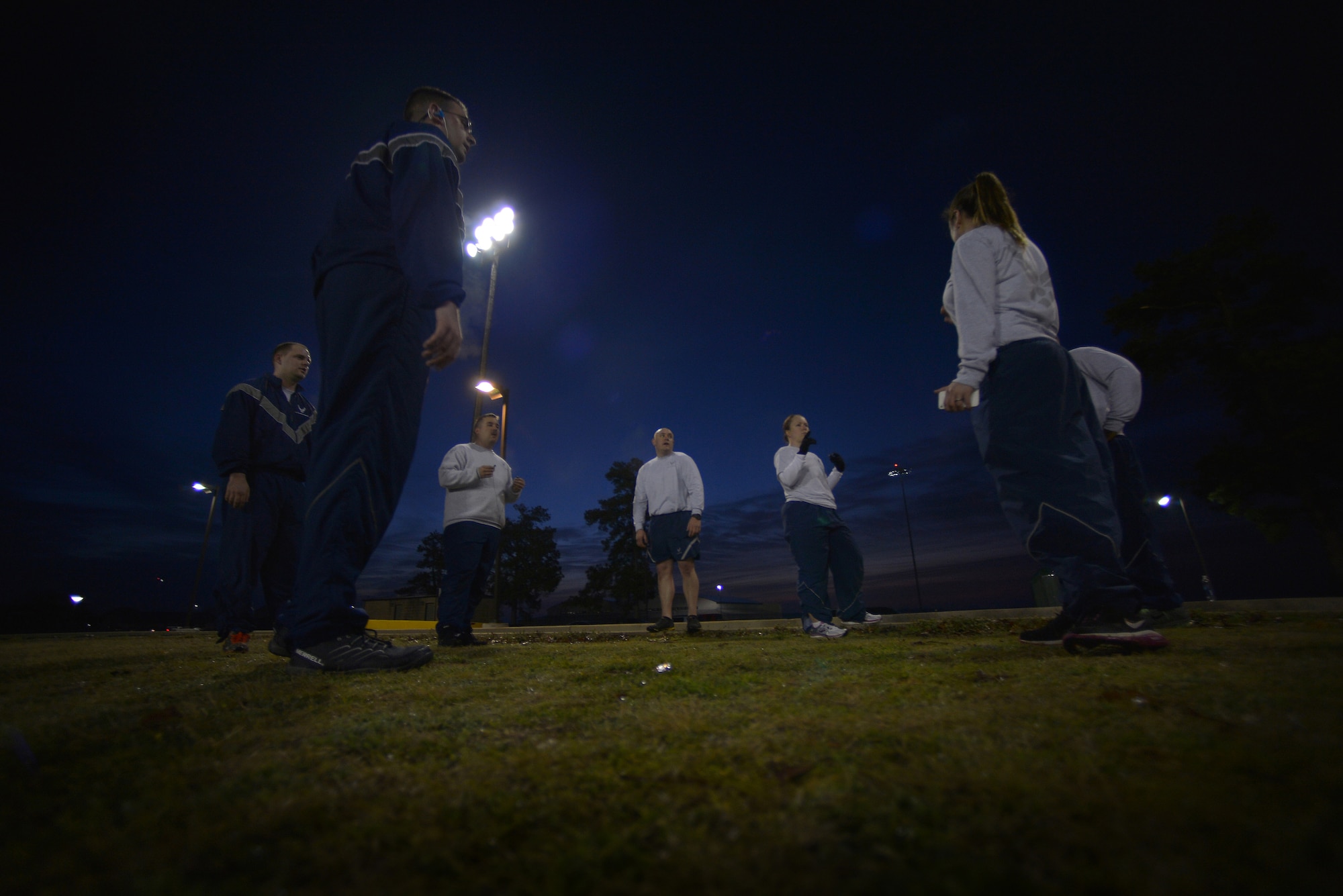 U.S. Air Force Airmen assigned to the 20th Logistics Readiness Squadron prepare to stretch during an early morning physical training session, March 20, 2014, Shaw Air Force Base, S.C. Recently military members have had to conduct physical training during hours of darkness due to daylight saving time. While military members can’t let the time change stop them from training to be fit to fight, they are encouraged to wear proper reflective gear when performing physical training during hours of darkness. (U.S. Air Force photo by Staff Sgt. Kenny Holston/Released)