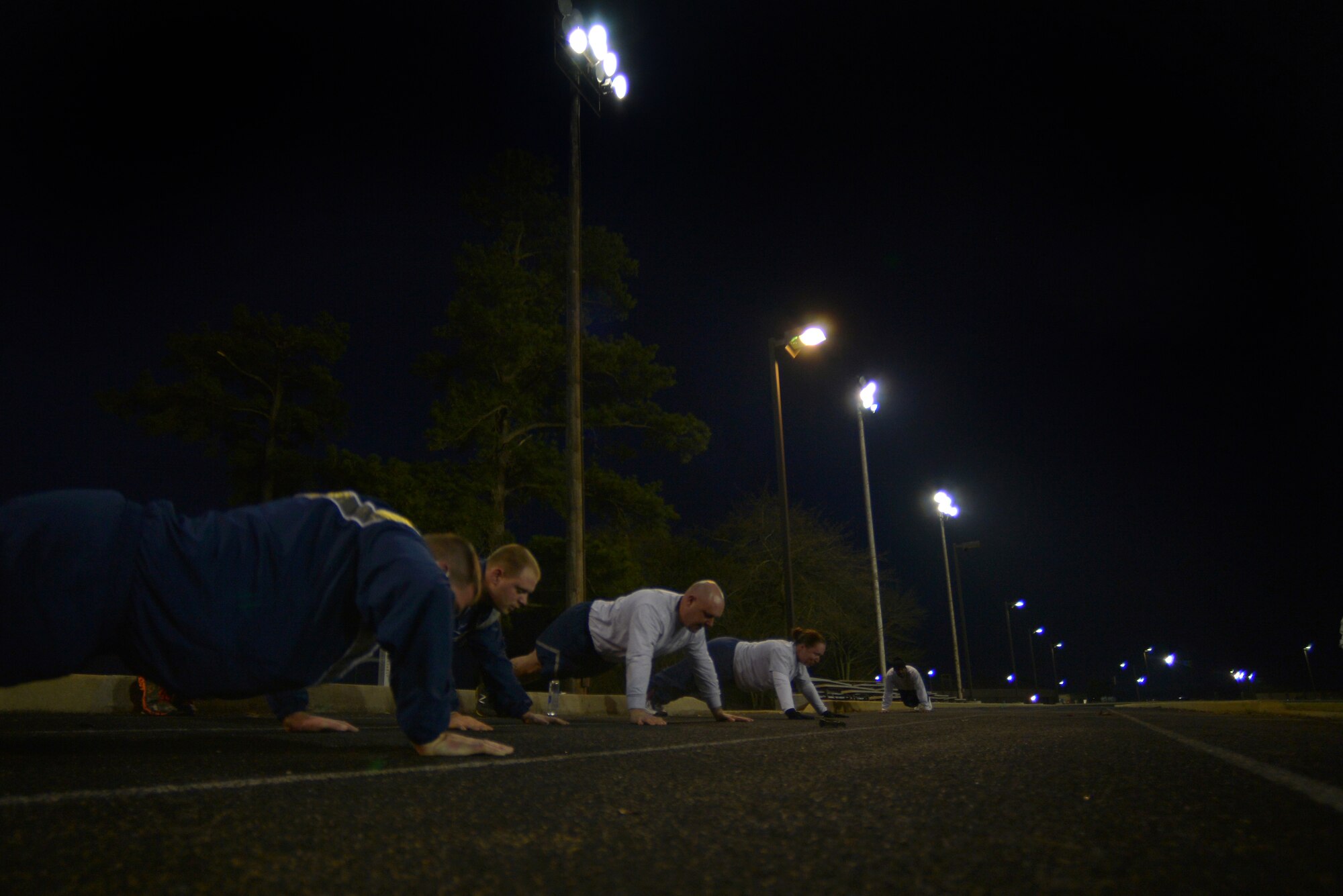 U.S. Air Force Airmen assigned to the 20th Logistics Readiness Squadron do pushups during an early morning physical training session, March 20, 2014, Shaw Air Force Base, S.C. Physical training is a top priority for military members to be prepared and equipped for any physical challenge they may face when conducting the mission. As military members conduct their physical training during this time of year they are reminded to operate safely when training during the hours of darkness. (U.S. Air Force photo by Staff Sgt. Kenny Holston/Released)
