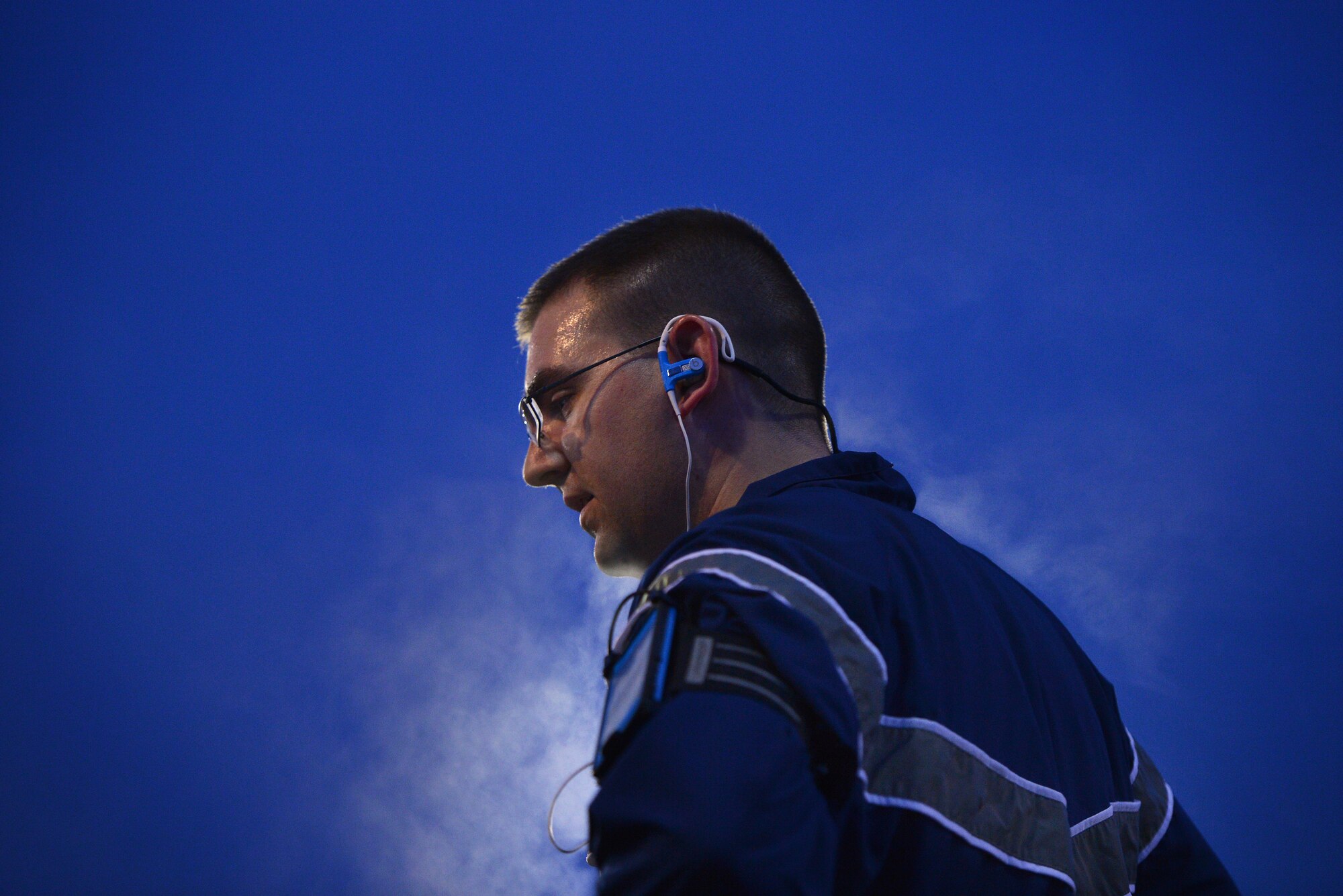 U.S. Air Force Staff Sgt. Troy Martin, 20th Logistics Readiness Squadron fuels controller, takes a breather in between work out segments while doing physical training with his unit on a cold dark morning, March 20, 2014, Shaw Air Force Base, S.C. daylight saving time has played a factor for some units that conduct early morning physical training sessions. These units now have to take in account low light conditions. To counter the less than optimal physical training conditions military members are encouraged to wear proper reflective gear and take the necessary measures to stay safe when training during the hours of darkness. (U.S. Air Force photo by Staff Sgt. Kenny Holston/Released) 