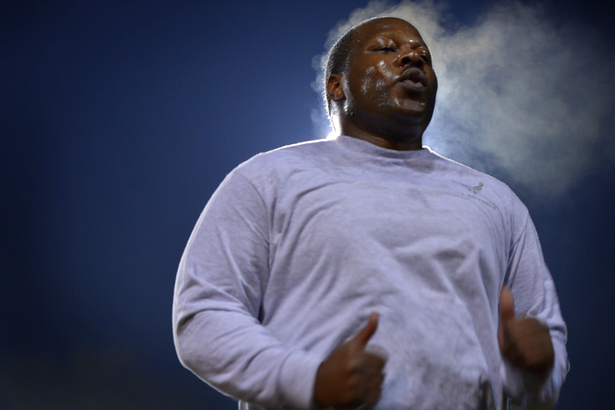 Steam emits from Staff Sgt. Chauncey Hunter, 20th Logistics Readiness Squadron command support staff NCOIC as he does physical training with his unit during a cold morning, March 20, 2014, Shaw Air Force Base, S.C. Recently military members have had to conduct physical training during hours of darkness due to daylight saving time. While military members can’t let the time change stop them from training to be fit to fight, they are encouraged to wear proper reflective gear when performing physical training during hours of darkness. (U.S. Air Force photo by Staff Sgt. Kenny Holston/Released)