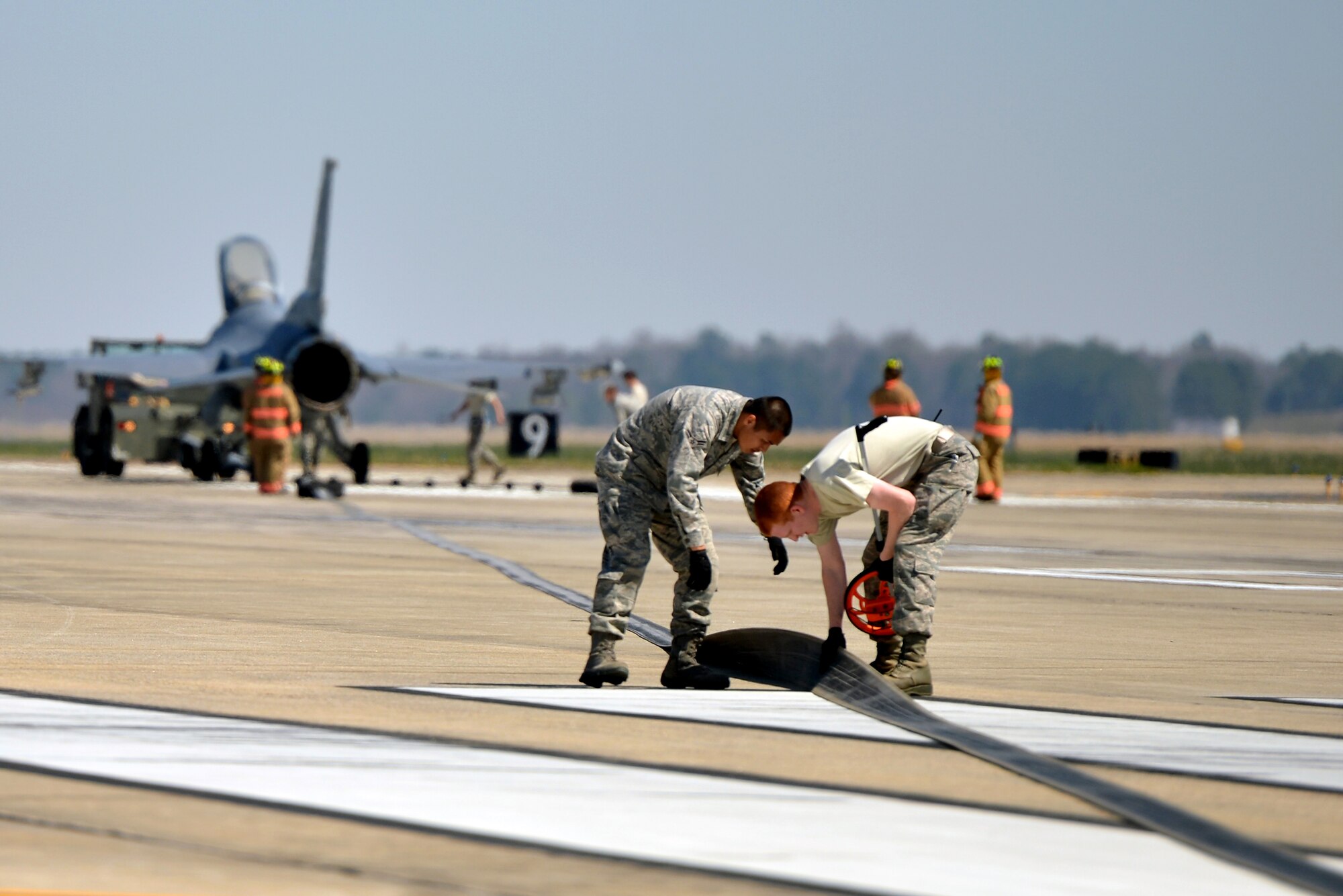 U.S. Air Force Airman 1st Class Kenneth Jimenez, (left) and Senior Airman Bryce Skawski, 20th Civil Engineer Squadron, perform inspections during the testing of an Aircraft Arresting System, March 21, 2014, Shaw Air Force Base, S.C. The AAS is required to be tested annually. 20th CES Airmen are reasonable for setting up the system and logging any deficiencies during the test. (U.S. Air Force photo by Staff Sgt. Kenny Holston/Released)