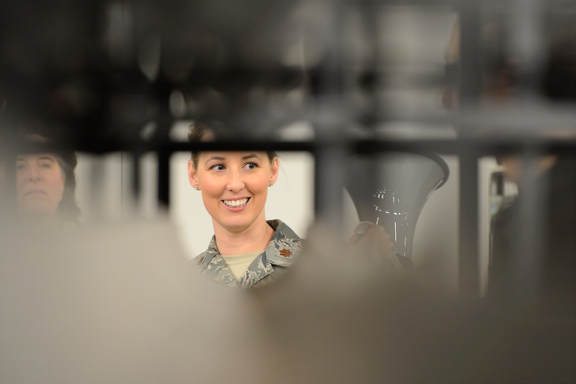 Major Rayna Lowery, 436th Logistics Readiness Squadron commander, is framed by a unique shelving and storage system created to keep long and flexible items stored safety within the LRS warehouse during a tour by the 2014 Honorary Commanders on March 21, 2014, at Dover Air Force Base, Del. The storage system is a point of pride for the unit and has increased safety and decreased lost material due to damage from improper storage. (U.S. Air Force photo/Greg L. Davis)