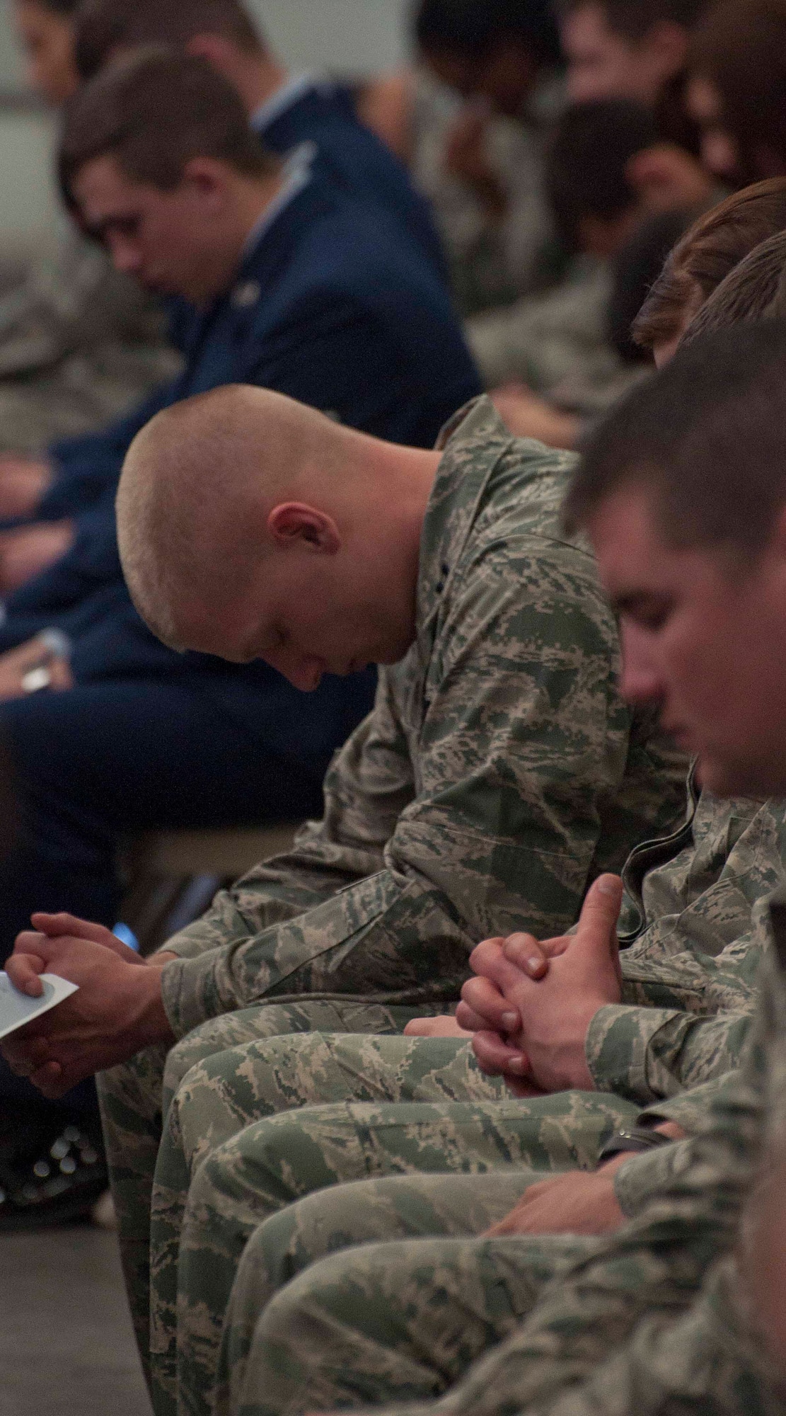 Friends of Airman 1st Class Dominique Hudson bow their heads in remembrance of Hudson March 21 during a memorial service in the Peacekeeper High Bay, Bldg. 1501.  (U.S. Air Force photo by Airman 1st Class Brandon Valle)
