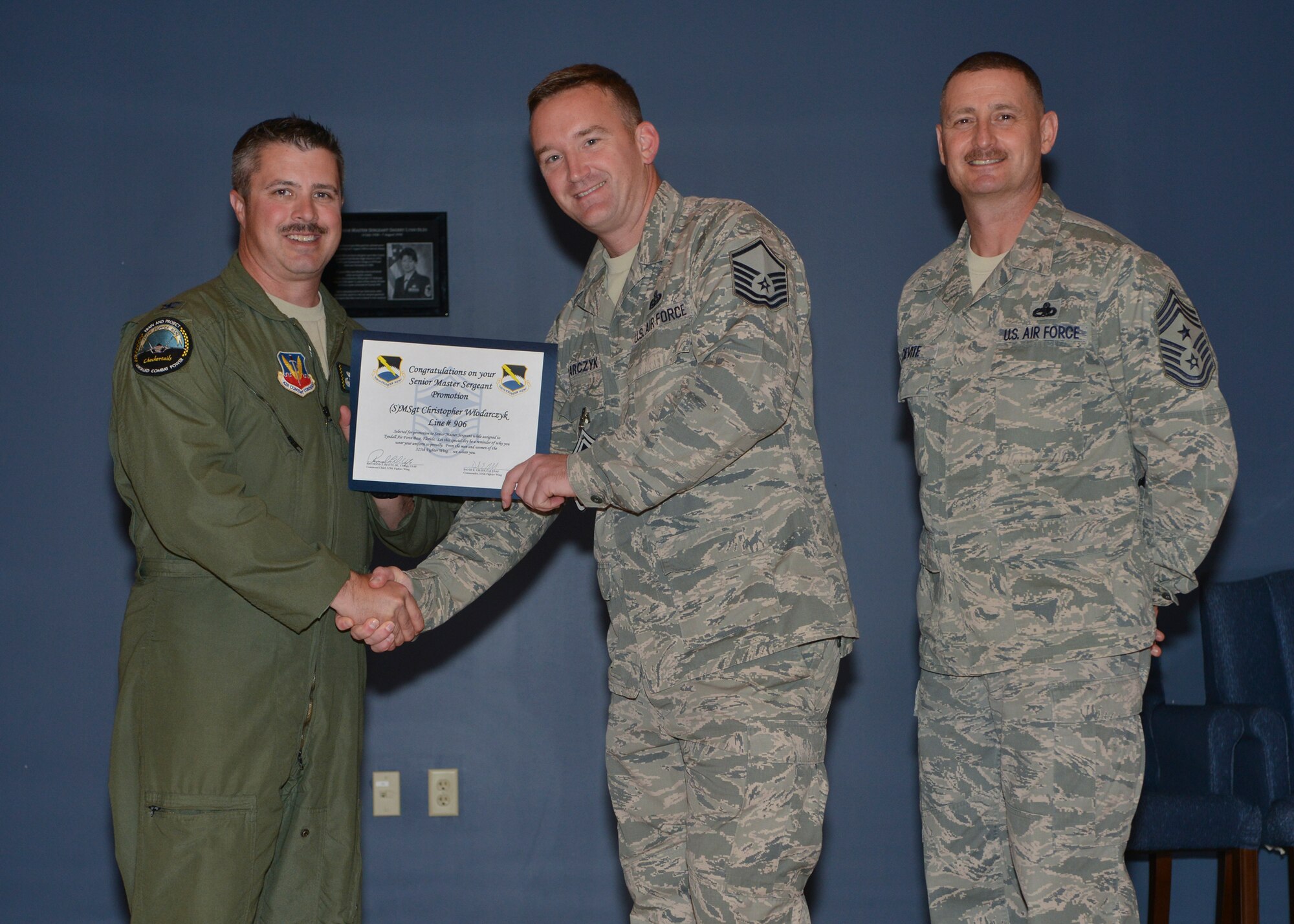 Col.l David E. Graff, 325th Fighter Wing commander (left) and Chief Master Sgt. Raymond F. DeVite, 325th FW Command Chief Master Sergeant (far right), present Master Sgt.Christopher Wlodarczyk, 325th Communications Squadron (middle) with his senior master sergeant promotion line number certificate March 21 at the Horizons ballroom. Team Tyndall recognized nine senior master sergeants promotes.  (U.S. Air Force photo by Staff Sgt. Javier Cruz)