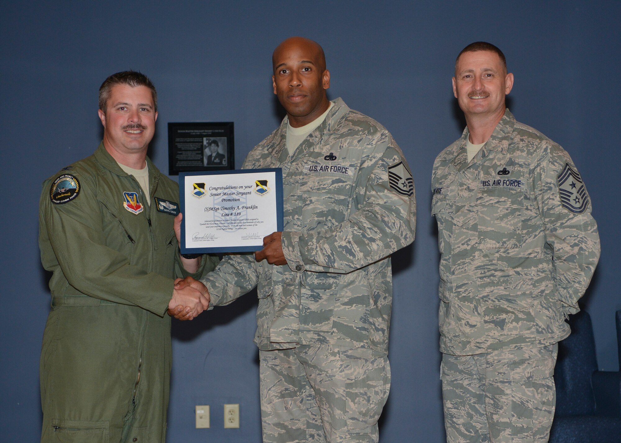 Col. David E. Graff, 325th Fighter Wing commander (left) and Chief Master Sgt. Raymond F. DeVite, 325th FW Command Chief Master Sergeant (far right), present Master Sgt. Timothy A. Franklin, 325th Maintenance Squadron (middle) with his senior master sergeant promotion line number certificate March 21 at the Horizons ballroom. Team Tyndall recognized nine senior master sergeants promotes.  (U.S. Air Force photo by Staff Sgt. Javier Cruz)