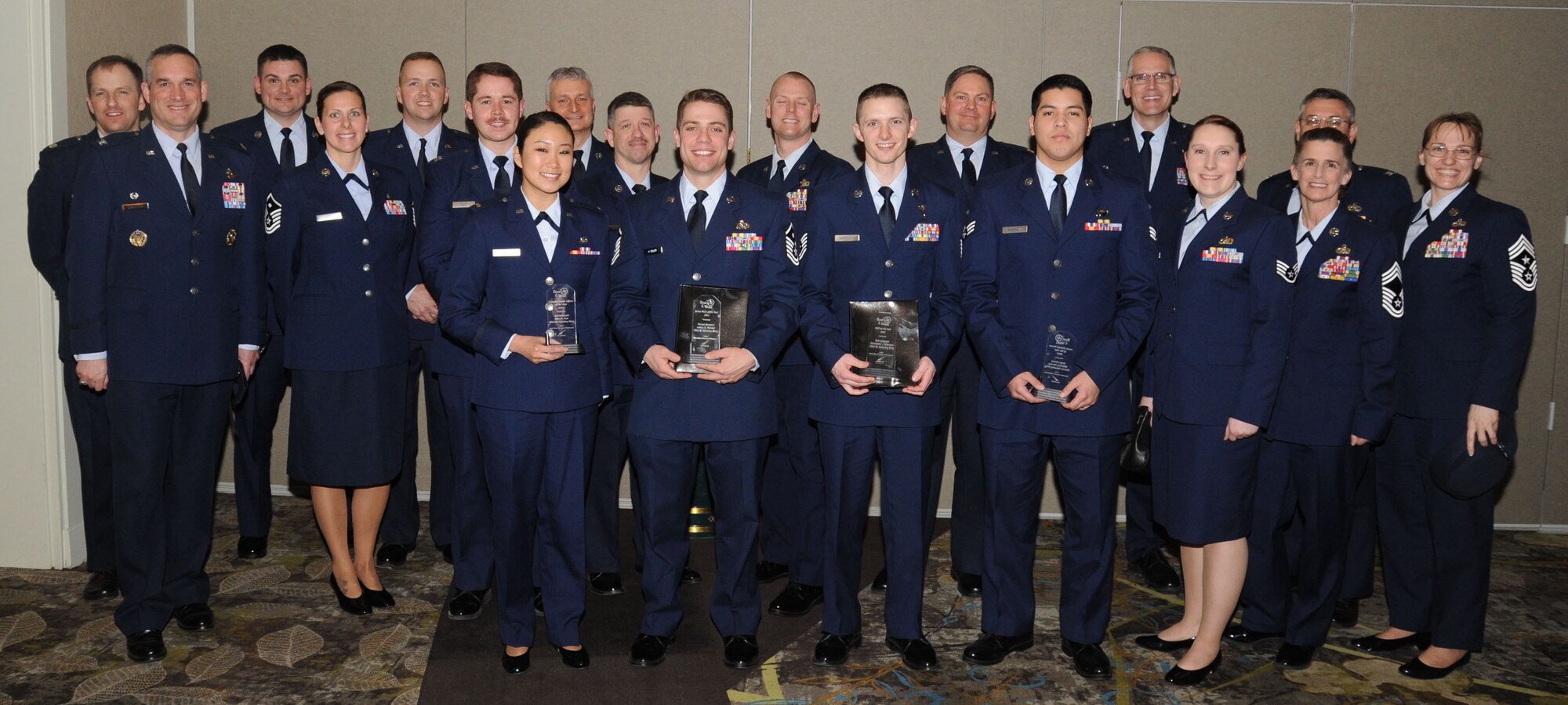2nd Lt. Helen Park, Master Sgt. Joshua Daneker, Tech. Sgt. Christopher Marrazzo and Senior Airman Richard Narvaez pose for a photo with their awards, in front of their supervision, at the Best of the West Awards ceremony in Airway Heights, Wash., March 20, 2014. The awards were given by the West Plains Chamber of Commerce for outstanding community contributions of company grade officers, senior NCOs, NCOs and Airmen. (U.S. Air Force photo by Airman 1st Class Sam Fogleman/Released)