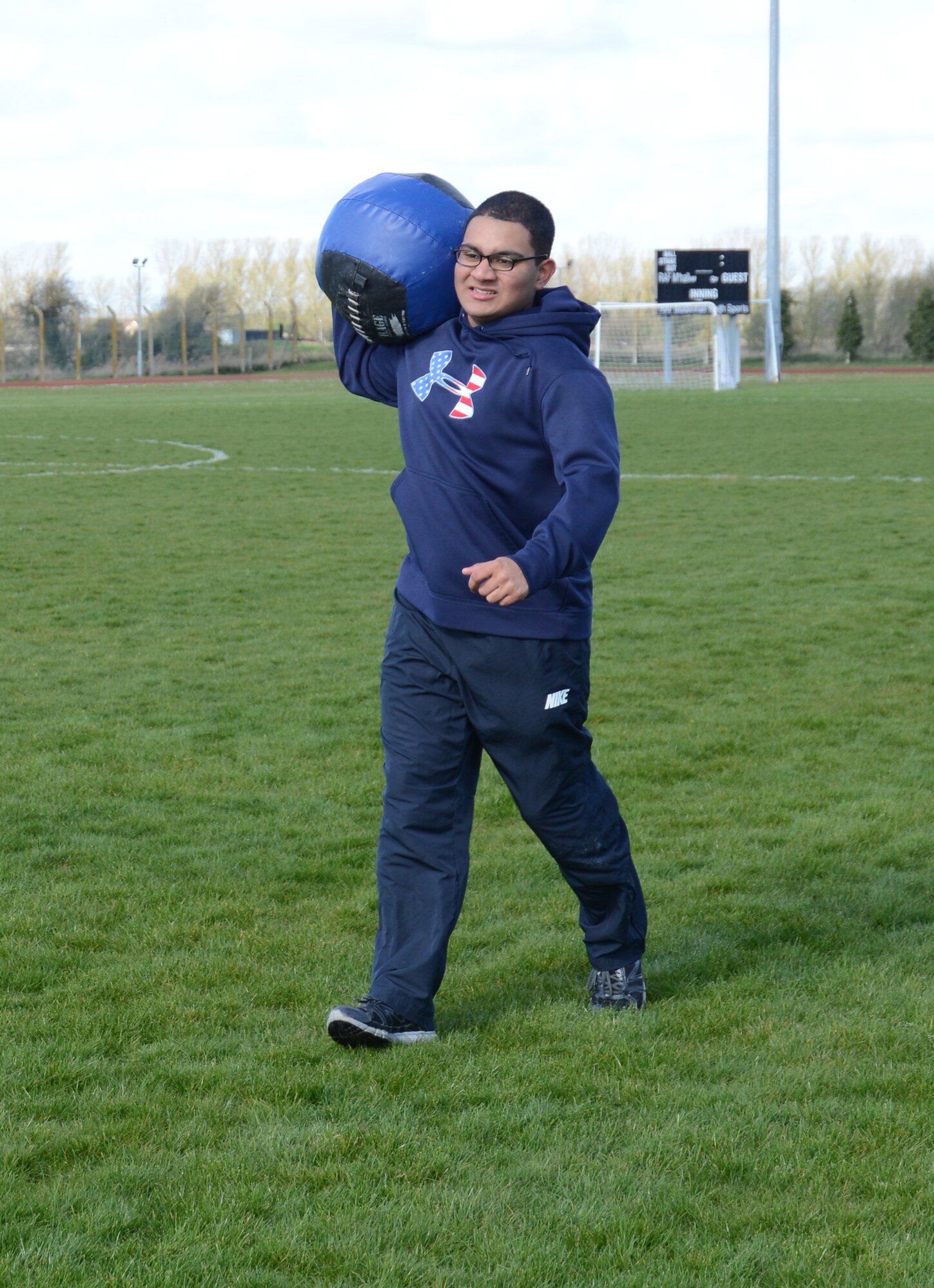 U.S. Air Force Airman 1st Class Carlos Ferran-Vargas, 100th Force Support Squadron fitness specialist from Colorado Springs, Colo., carries a medicine ball during a group event in a weight-loss competition March 22, 2014, on RAF Mildenhall, England. The event included running, speed walking, a sled pull and a medicine-ball carry. The group-event competition was worth a total of 10 points: four points for winning the competition, one for having the fastest walker and one point to each of the five teams that participated. The points will be added to the teams’ final scores during the final weigh-in March 28. (U.S. Air Force photo by Airman 1st Class Kelsey Waters/Released)