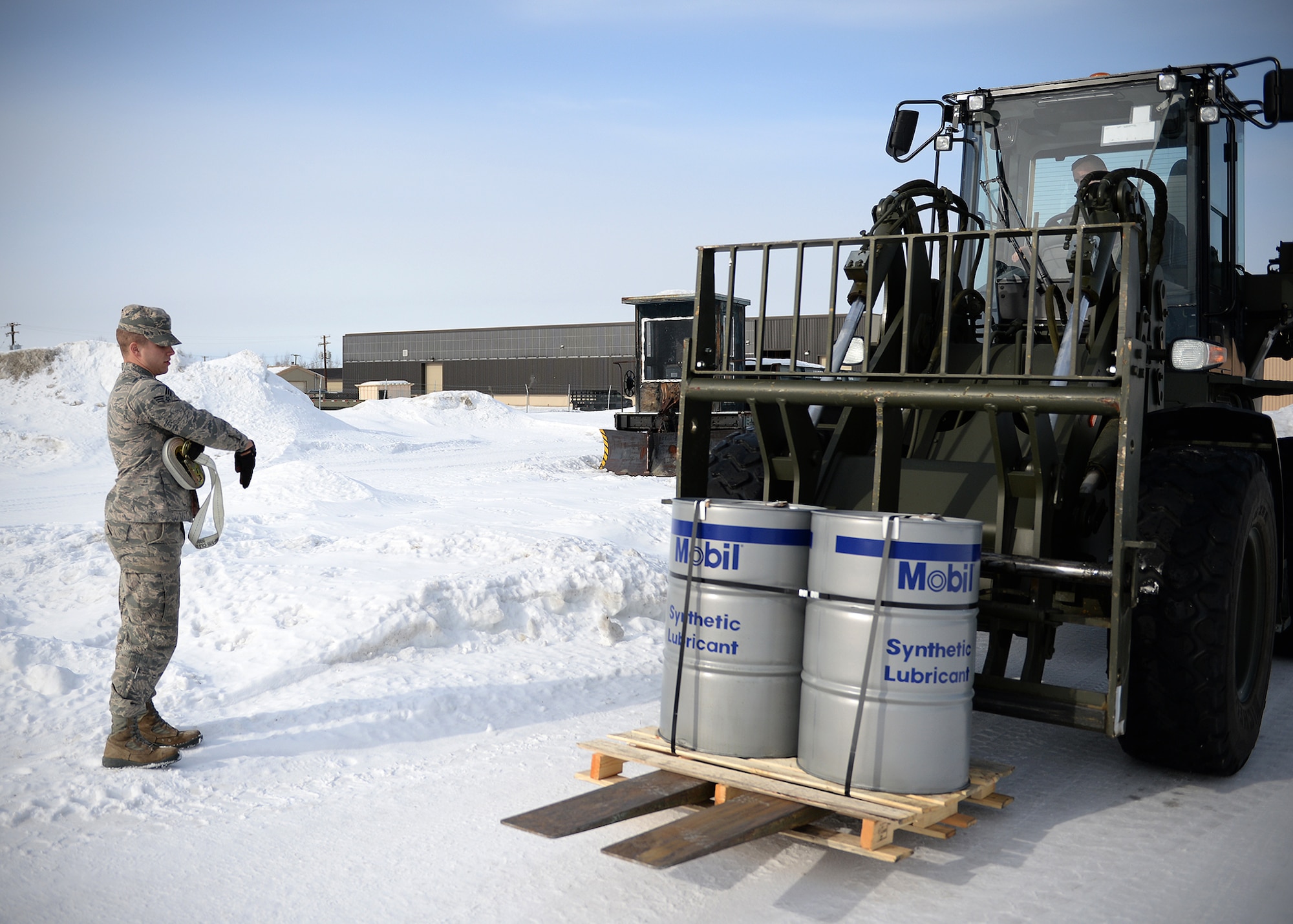 Senior Airman Gregory Bloomquist, 354th Logistic Readiness Squadron vehicle operator, directs a fork lift operator March 18, 2014 Eielson Air Force Base, Alaska. The vehicle operations flight controls more than 80 vehicles to help Eielson support its day-to-day missions and keep aircraft in the sky during RED FLAG-Alaska. (U.S. Air Force photo by Staff Sgt. Shawn Nickel/Released)