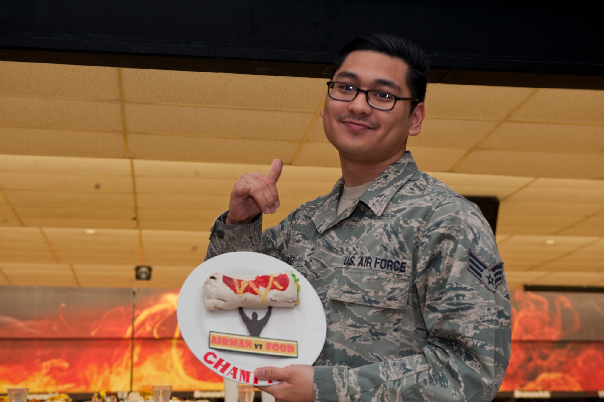 Senior Airman Antonio Cruz, 49th Aerospace Medical Squadron public health technician, celebrates tying for first place in the Airman vs. Food eating competition at Holloman Air Force Base, N.M., March 13. Ace’s Ten Pin Cantina at the HAFB bowling alley hosted an eating competition in which participants had 20 minutes to eat five-pound burritos. (U.S. Air Force photo by Airman 1st Class Aaron Montoya / Released)