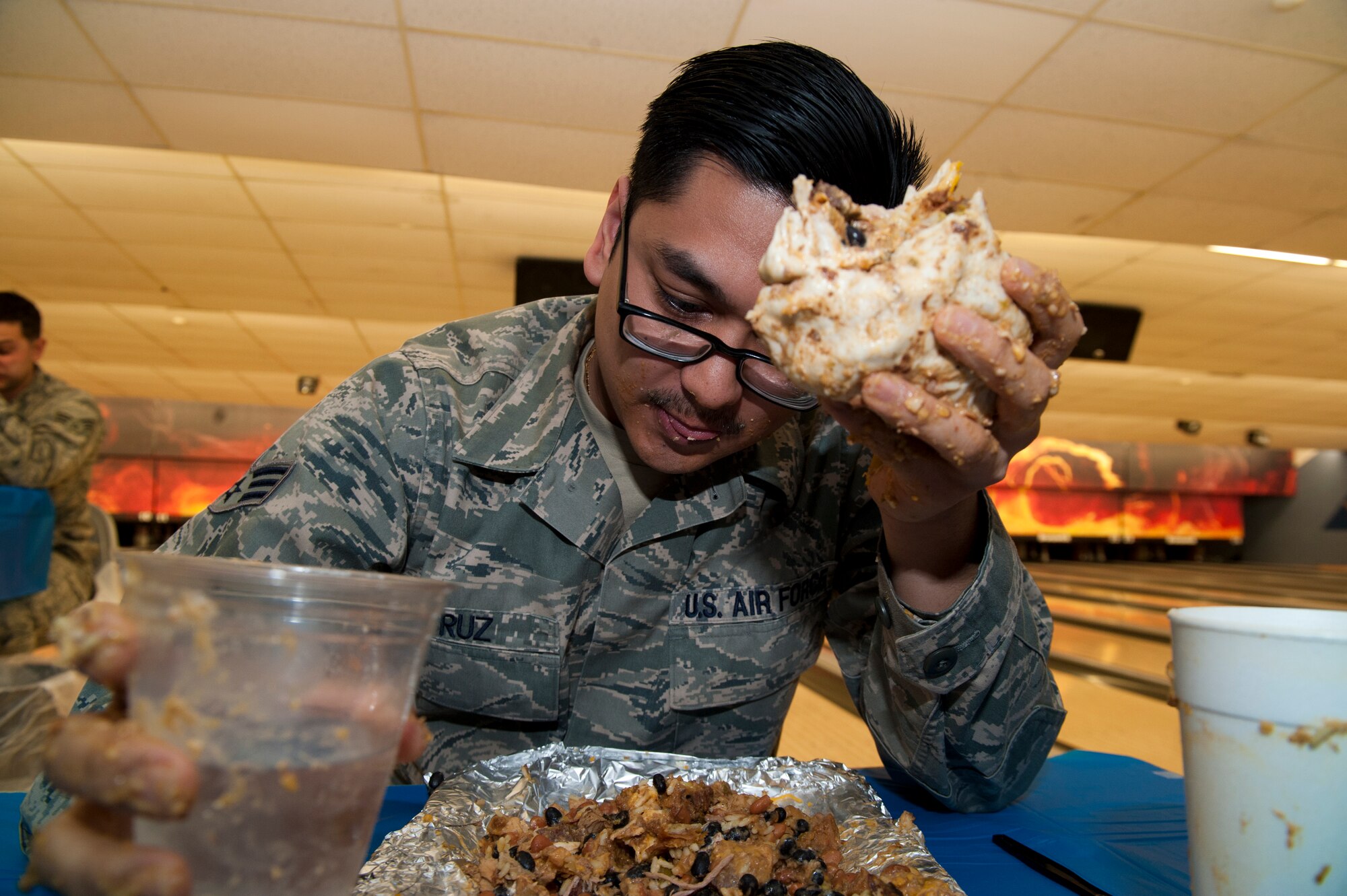 Senior Airman Antonio Cruz, 49th Aerospace Medical Squadron public health technician, competes in the Airman vs. Food eating competition at Holloman Air Force Base, N.M., March 13. Ace’s Ten Pin Cantina at the HAFB bowling alley hosted an eating competition in which participants had 20 minutes to eat five-pound burritos. (U.S. Air Force photo by Airman 1st Class Aaron Montoya / Released)
