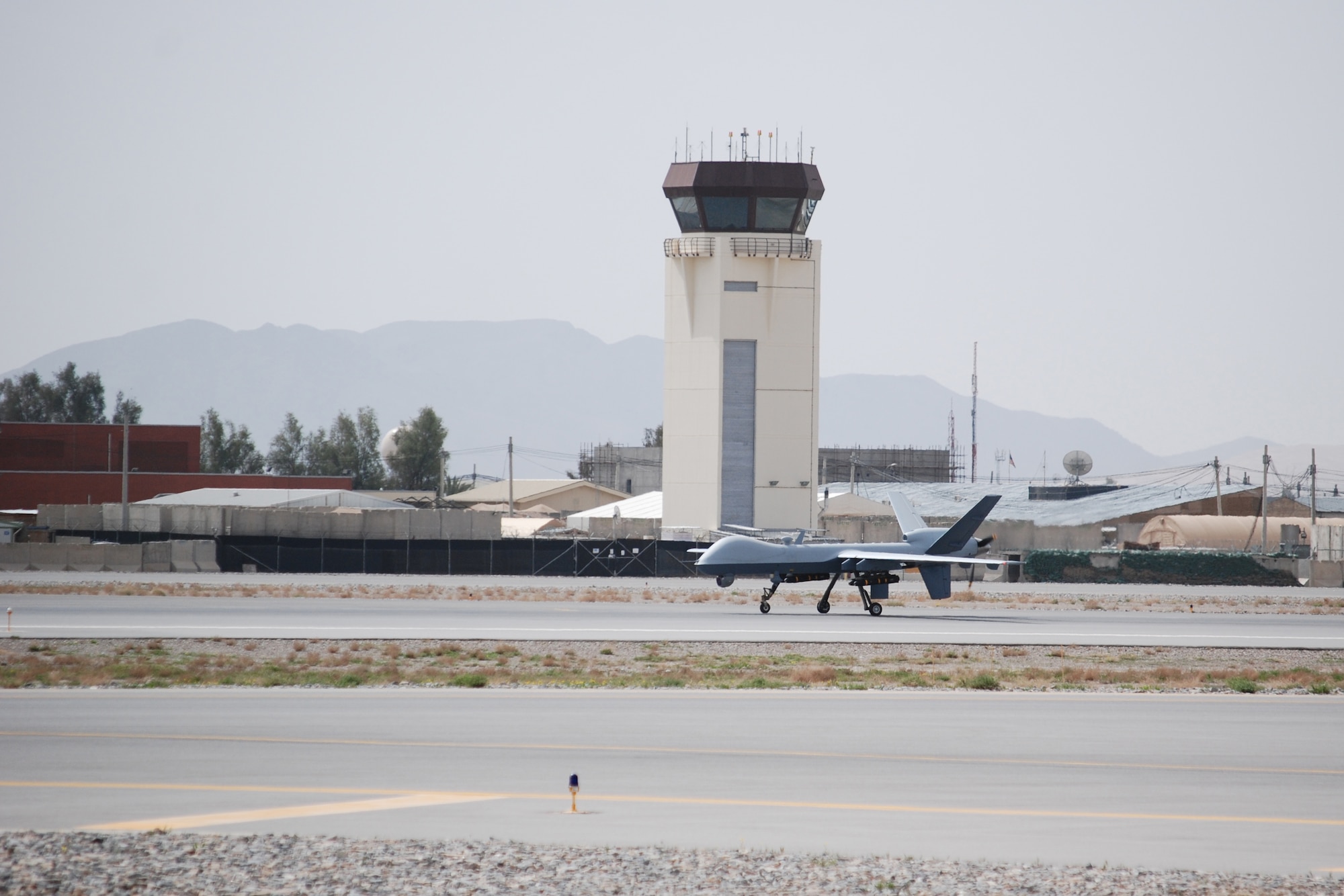 An MQ-9 Reaper taxis after landing at Kandahar Airfield, March 20, 2014. The MQ-9 is assigned to and operated by the 451st Air Expeditionary Group. (U.S. Air Force photo by Capt. Brian Wagner/Released) (A section of the MQ-9 was blurred for operational security reasons.)