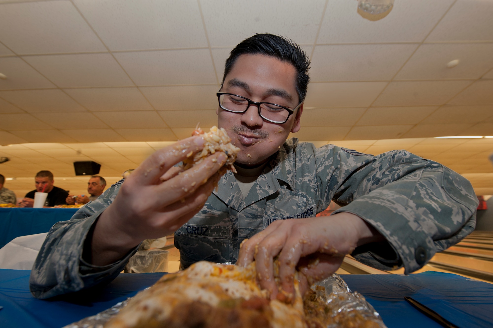 Senior Airman Antonio Cruz, 49th Aerospace Medical Squadron public health technician, competes in the Airman vs. Food eating competition at Holloman Air Force Base, N.M., March 13. Ace’s Ten Pin Cantina at the HAFB bowling alley hosted an eating competition in which participants had 20 minutes to eat five-pound burritos. (U.S. Air Force photo by Airman 1st Class Aaron Montoya / Released)