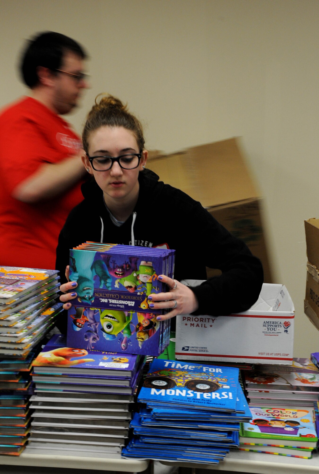 Colleen Heaney-Burcher, Burlington County College student, packs children’s books donated by First book in coordination with BCC to Joint Base McGuire-Dix-Lakehurst March 19, 2014, at the BCC campus in Mount Laurel, N.J. Heaney-Burcher became involved through the school’s First Year Initiative Program in which she participates in this and other volunteer efforts. (U.S. Air Force photo by Airman 1st Class Sean M. Crowe/Released)