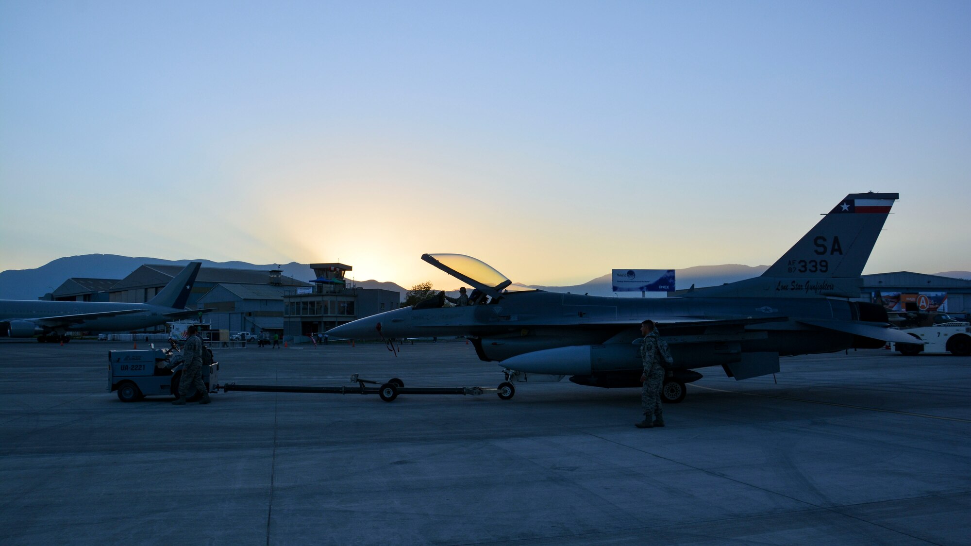 U.S. Air Force airmen tow an F-16 Fighting Falcon on the ramp at the FIDAE airshow in Santiago, Chile, March 24.  Nearly 60 U.S. airmen are participating in subject matter expert exchanges with Chilean air force counterparts during the week of FIDAE, and as part of the events will host static displays of the C-130 Hercules and F-16 Fighting Falcon during the FIDAE Air Show in Santiago, March 25-30. The exchanges, conducted regularly throughout the year, involve U.S. Airmen sharing best practices and procedures to build partnerships and promote interoperability with partner-nations throughout South America, Central America and the Caribbean. (U.S. Air Force photo by Capt. Justin Brockhoff/Released)